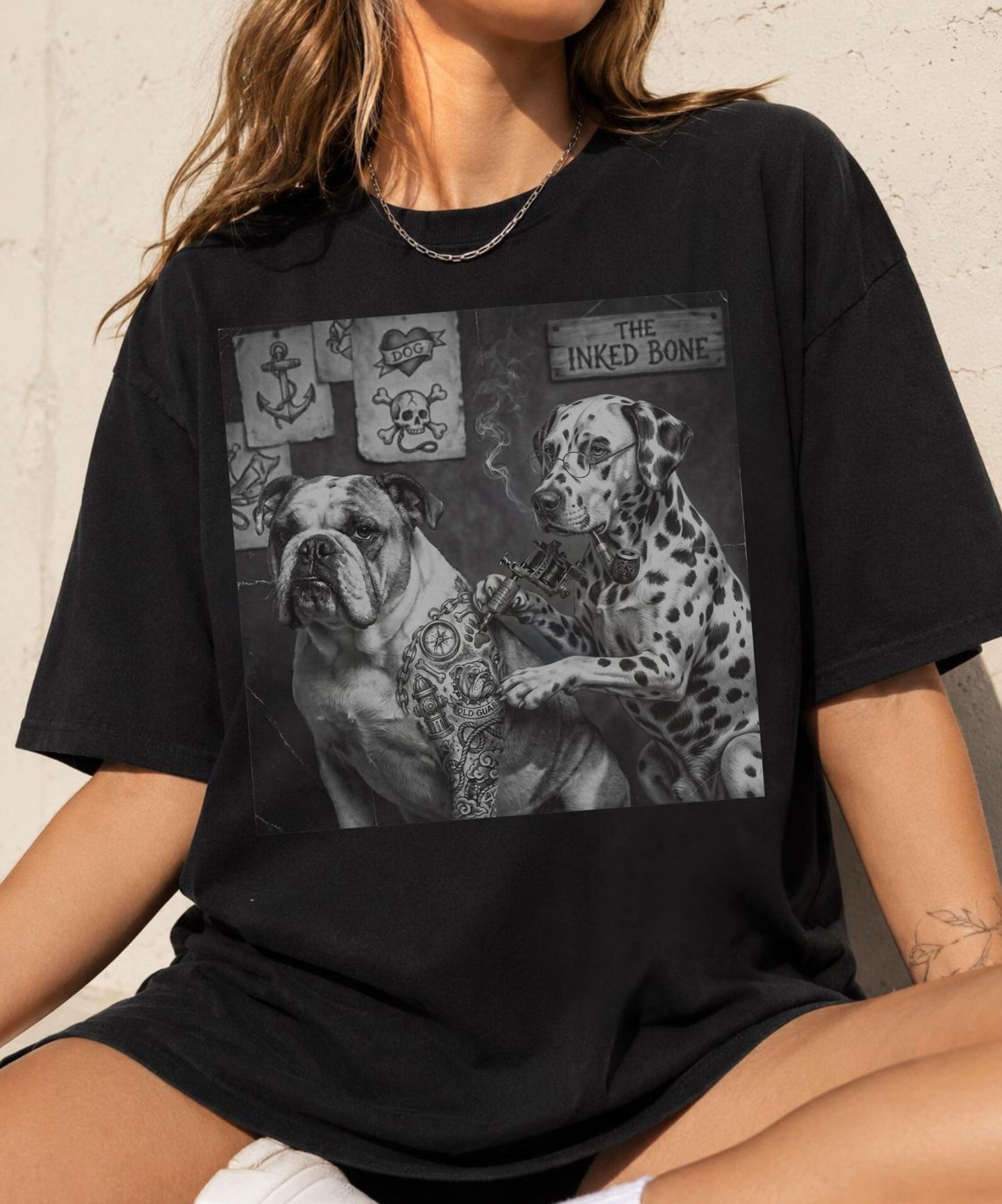  Woman wearing black garment-dyed graphic tee featuring vintage Bulldog and Dalmatian tattoo artist illustration — The Inked Bone design