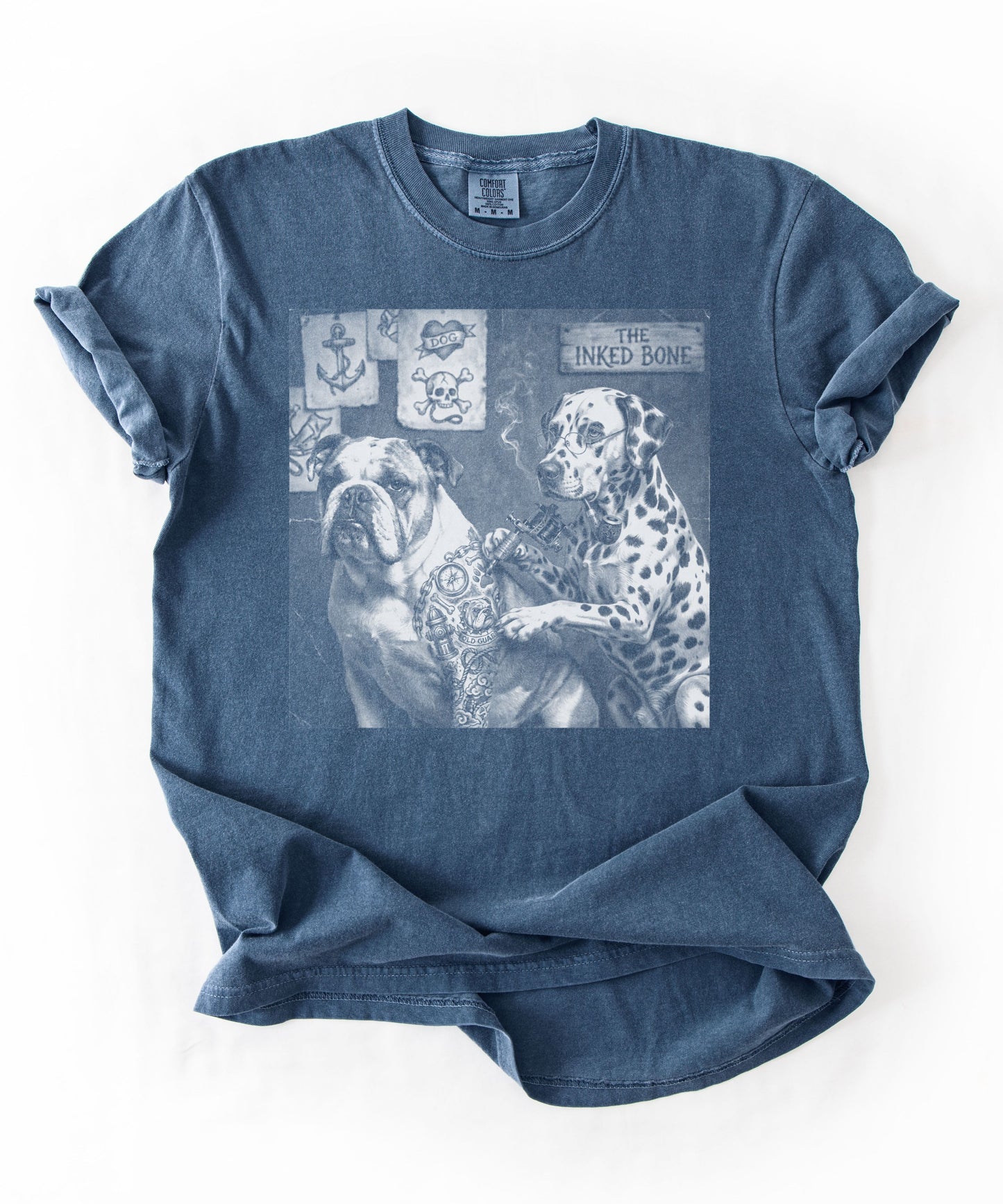  Denim blue garment-dyed tee laid flat showing Bulldog and Dalmatian tattoo artist graphic with anchor and skull flash art in background