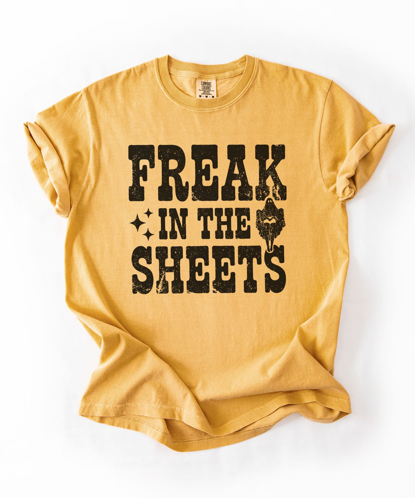 Mustard Comfort Colors Freak in the Sheets funny Halloween ghost graphic tee — distressed western lettering with ghost and sparkle accents, flat lay