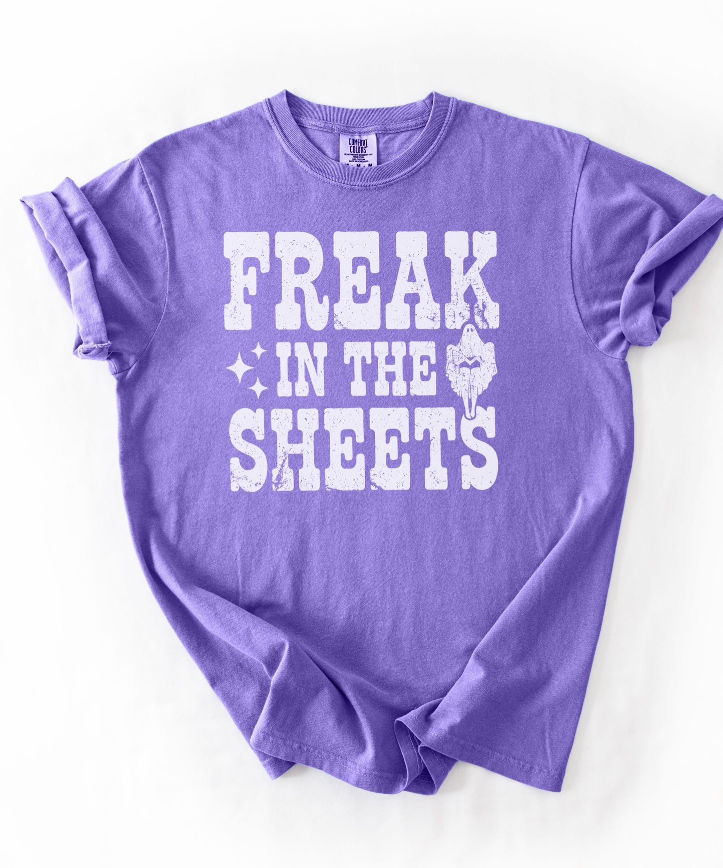 Violet Comfort Colors Freak in the Sheets funny Halloween ghost graphic tee — distressed western lettering with ghost and sparkle accents, flat lay