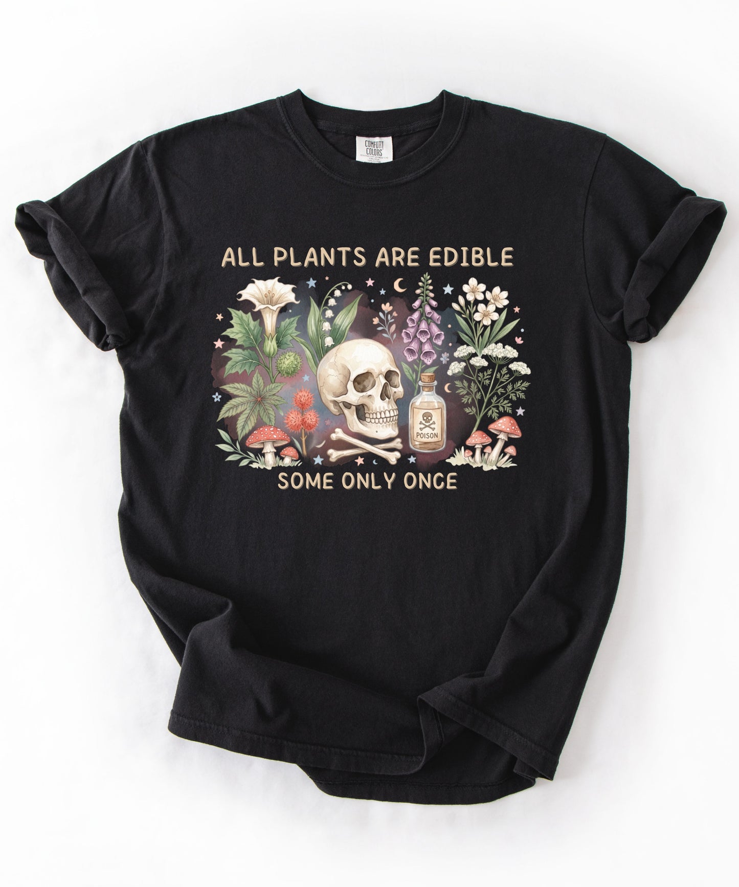 Botanical skull graphic tee featuring herbs, mushrooms, and skull illustration with phrase "All plants are edible, some only once" — front view on garment-dyed cotton Black Color