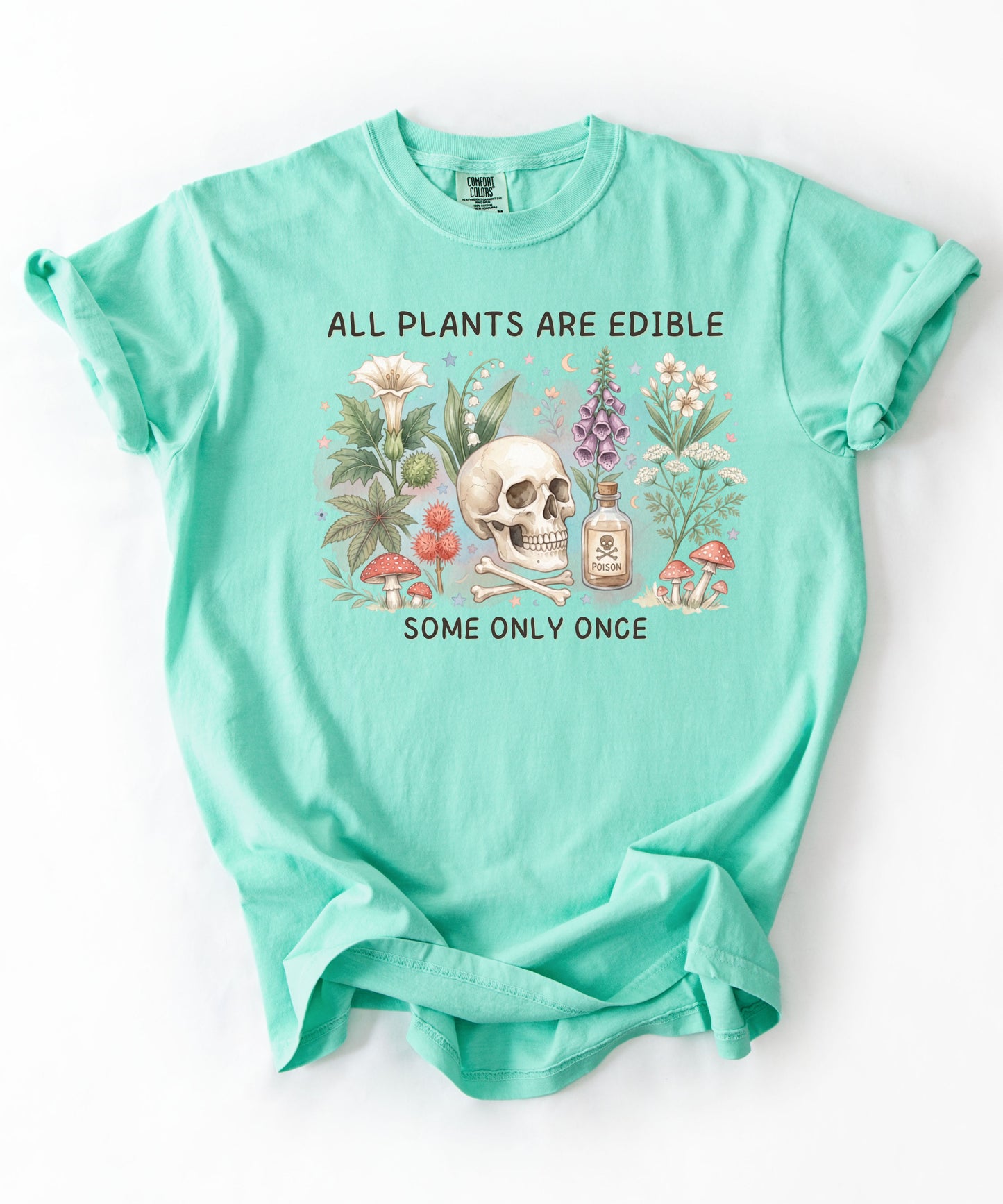 Botanical skull graphic tee featuring herbs, mushrooms, and skull illustration with phrase "All plants are edible, some only once" — front view on garment-dyed cotton Island Reef Color