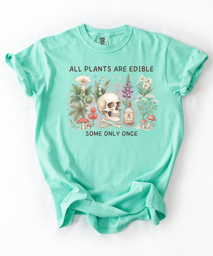 Botanical skull graphic tee featuring herbs, mushrooms, and skull illustration with phrase "All plants are edible, some only once" — front view on garment-dyed cotton Island Reef Color