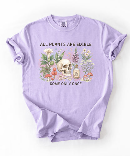 Botanical skull graphic tee featuring herbs, mushrooms, and skull illustration with phrase "All plants are edible, some only once" — front view on garment-dyed cotton Orchid Color