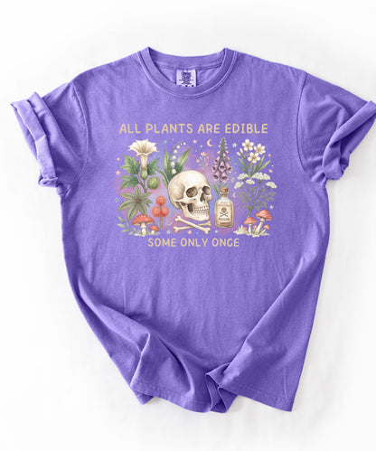 Botanical skull graphic tee featuring herbs, mushrooms, and skull illustration with phrase "All plants are edible, some only once" — front view on garment-dyed cotton Violet Color