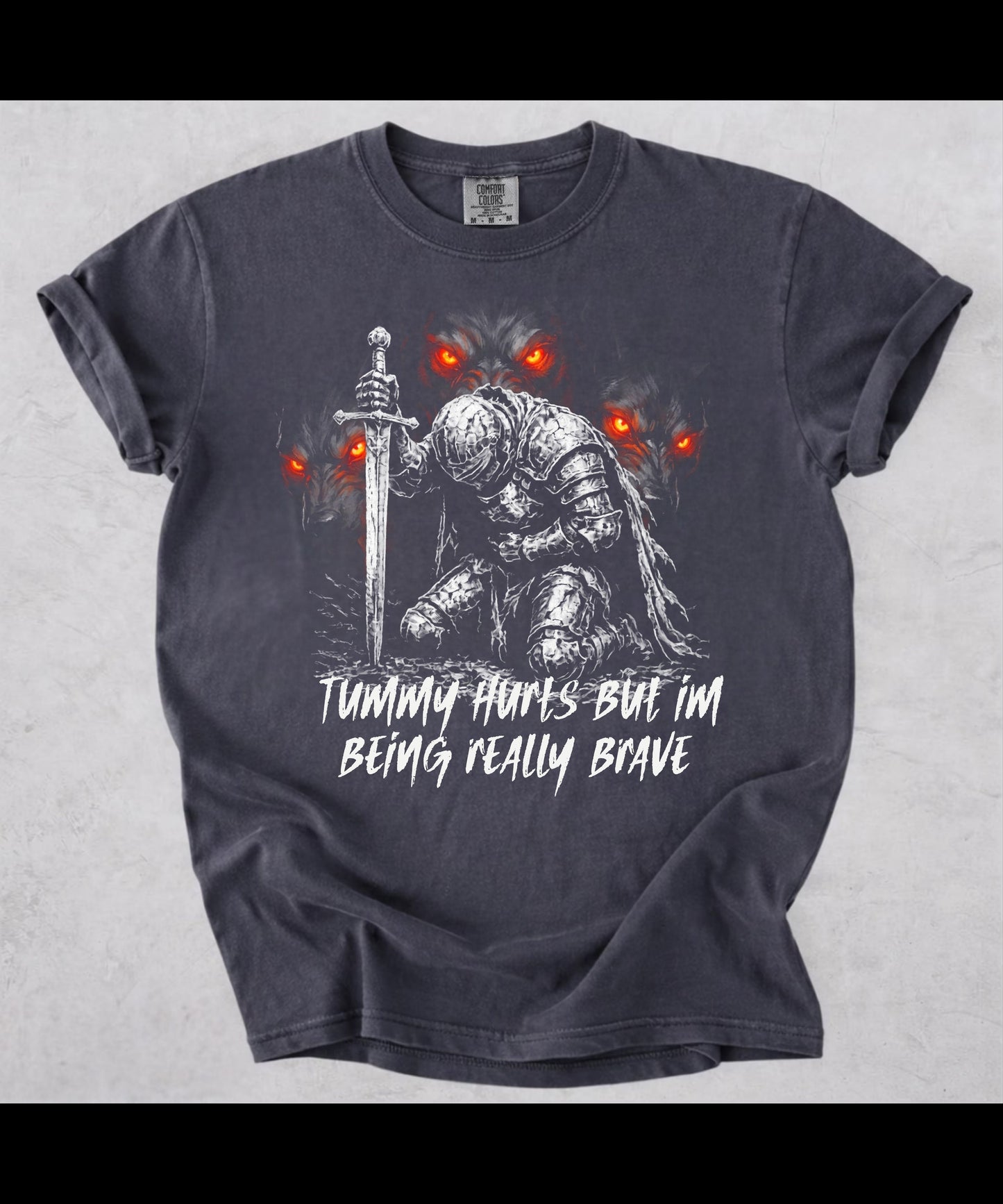 Funny knight graphic tee with Serverus and "Tummy Hurts But I'm Being Really Brave" text — Graphite color mockup showing relaxed fit