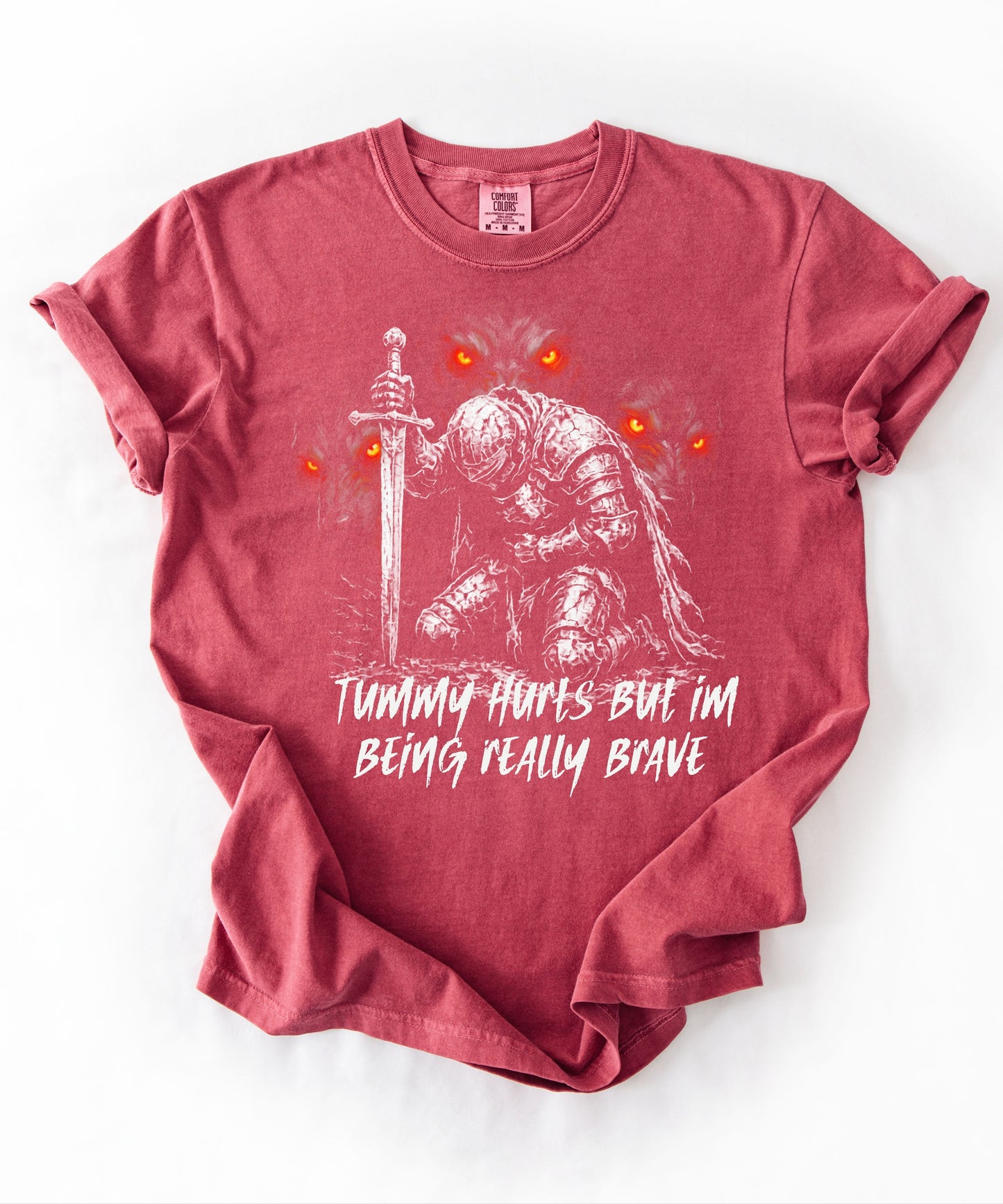 Funny knight graphic tee with Serverus and "Tummy Hurts But I'm Being Really Brave" text — Crimson color mockup showing relaxed fit