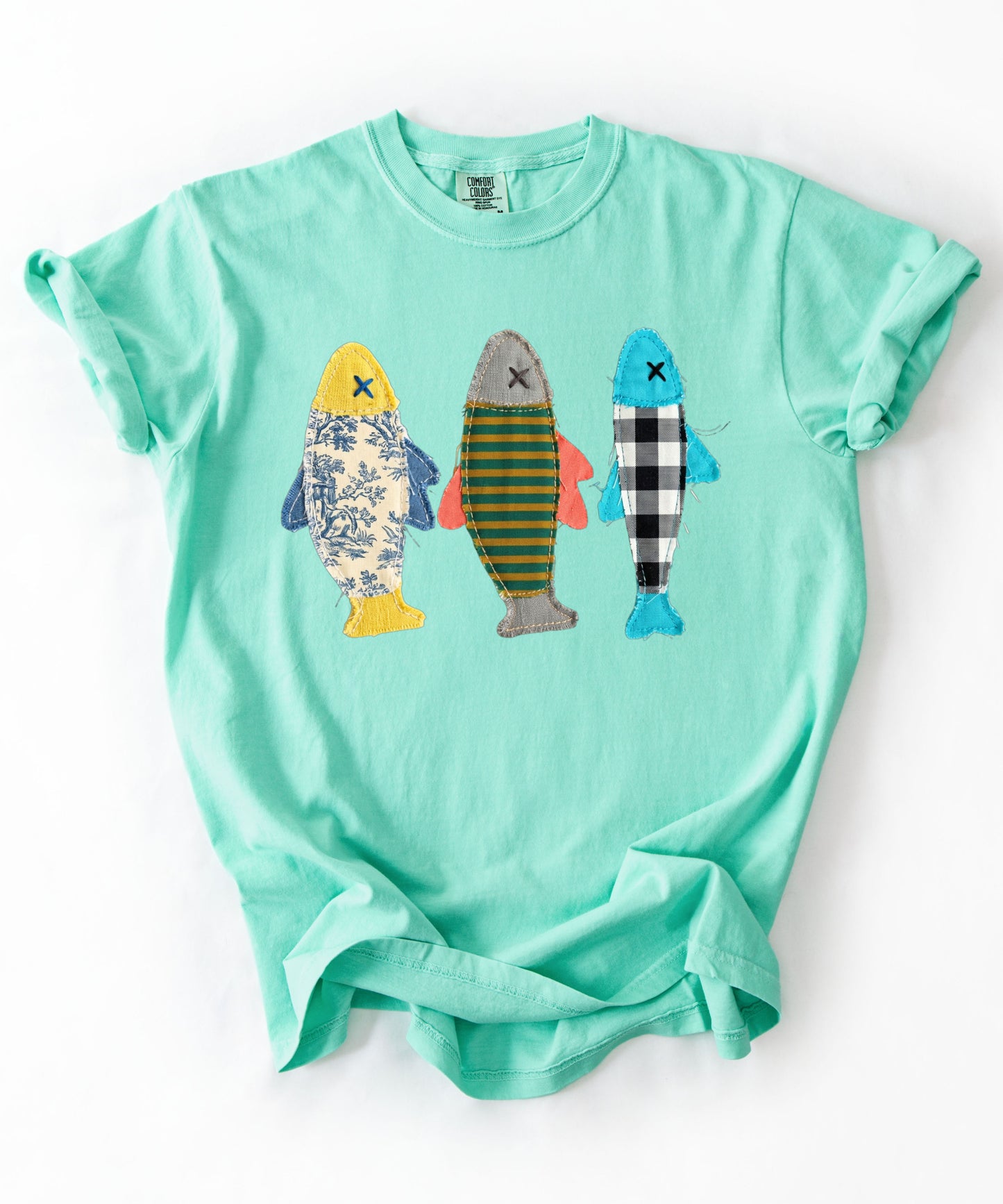 Faux patterned fish trio graphic tee in Island Reef featuring three fish in faux floral, faux stripe, and faux buffalo-check prints — front view on garment-dyed cotton