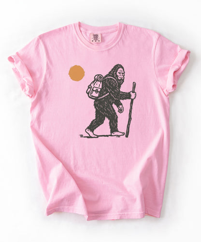 Bigfoot Hiker T-Shirt in Blossom — Sasquatch with backpack sunset graphic tee