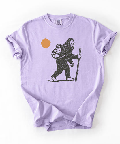 Bigfoot Hiker T-Shirt in Orchid — Sasquatch with backpack sunset graphic tee