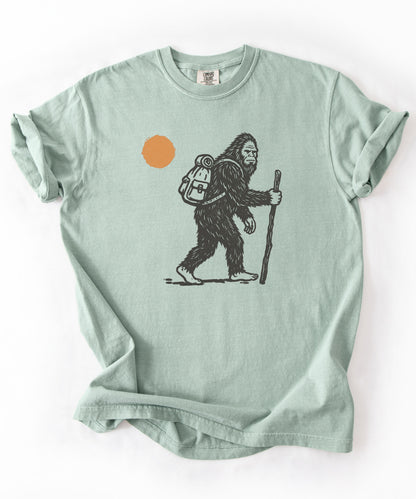 Bigfoot Hiker T-Shirt in Bay— Sasquatch with backpack sunset graphic tee