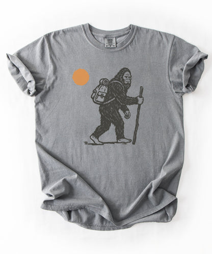 Bigfoot Hiker T-Shirt in Grey— Sasquatch with backpack sunset graphic tee
