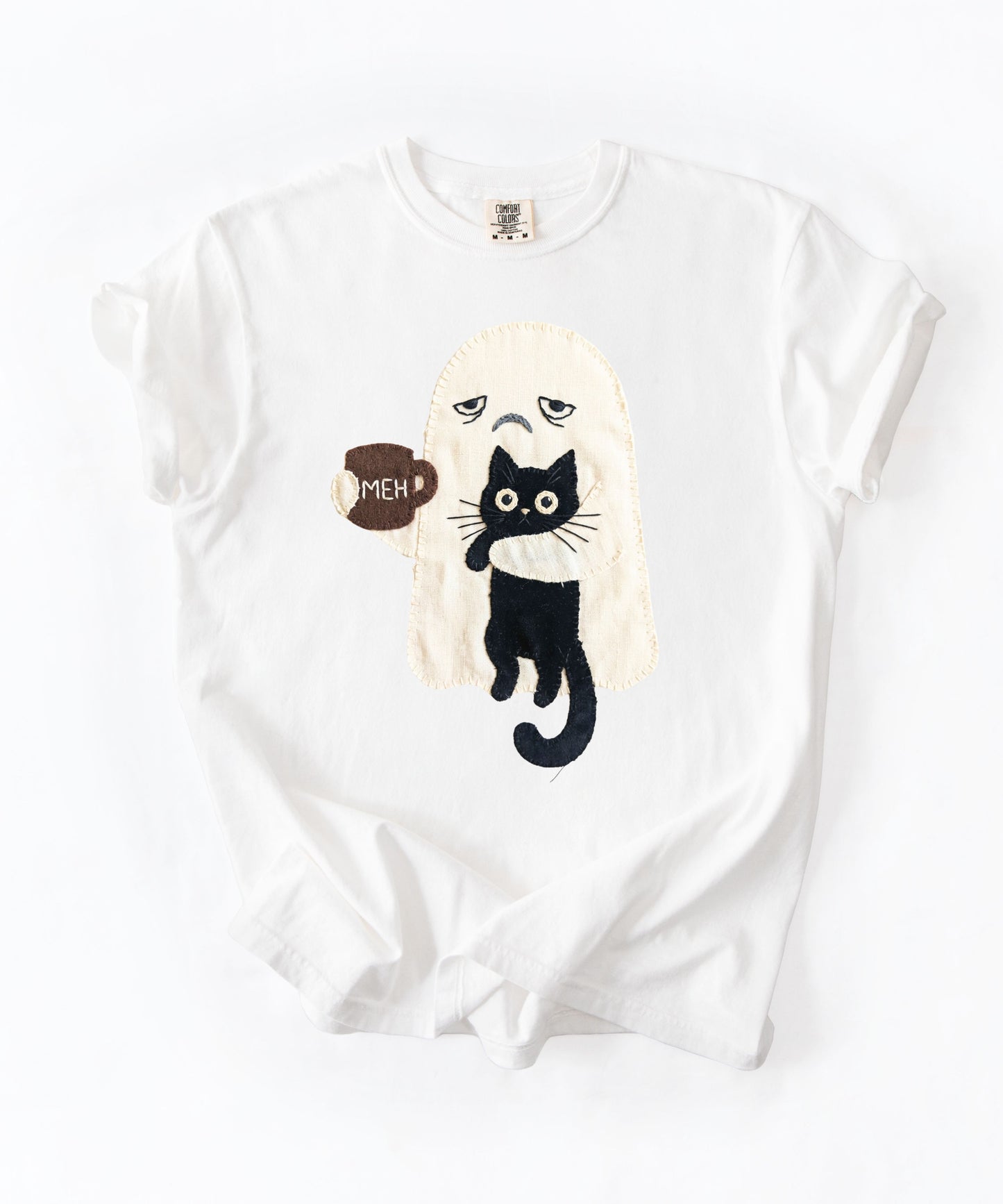 Grumpy ghost holding MEH mug with black cat graphic on White Comfort Colors garment-dyed tee