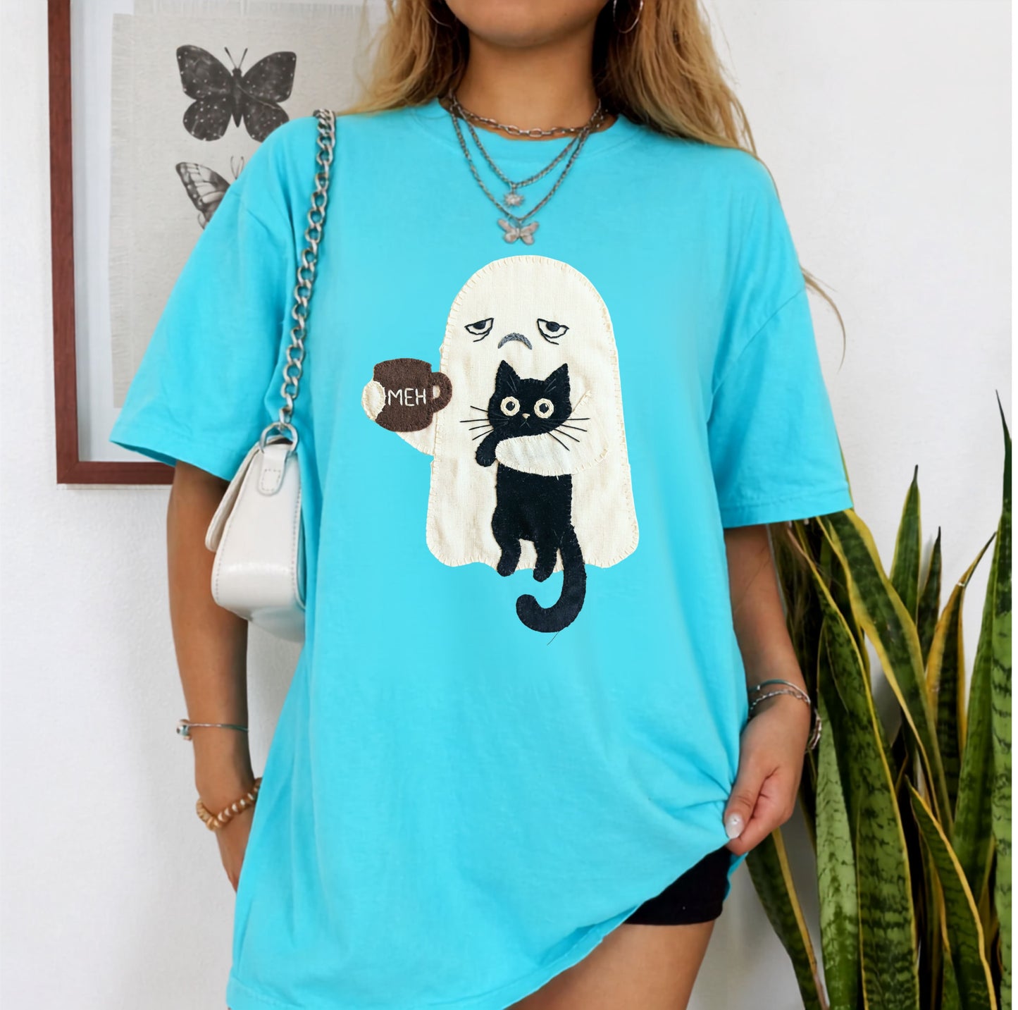 Grumpy ghost holding MEH mug with black cat graphic on Laggon Blue Comfort Colors garment-dyed tee
