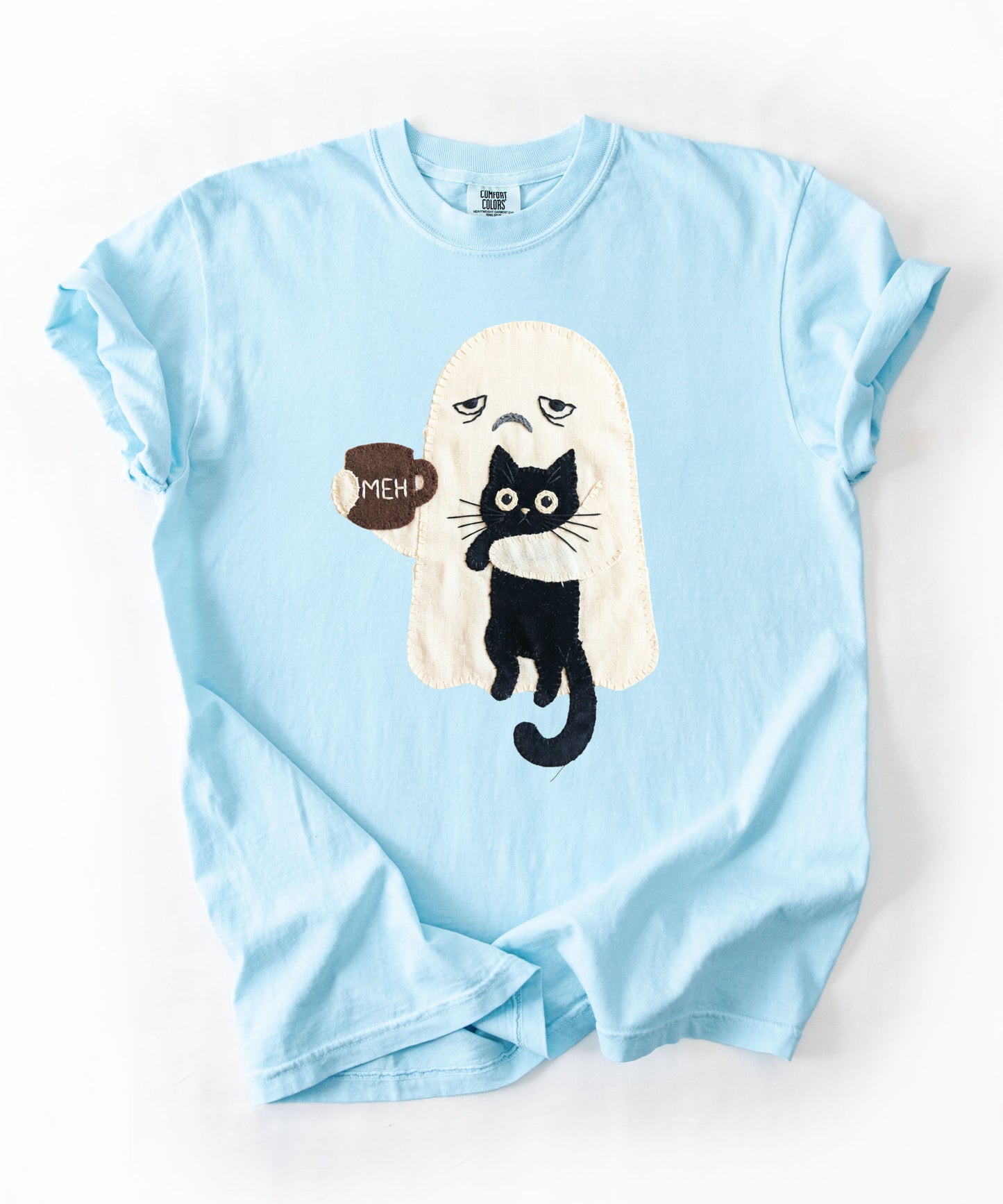 Grumpy ghost holding MEH mug with black cat graphic on Chambray Comfort Colors garment-dyed tee