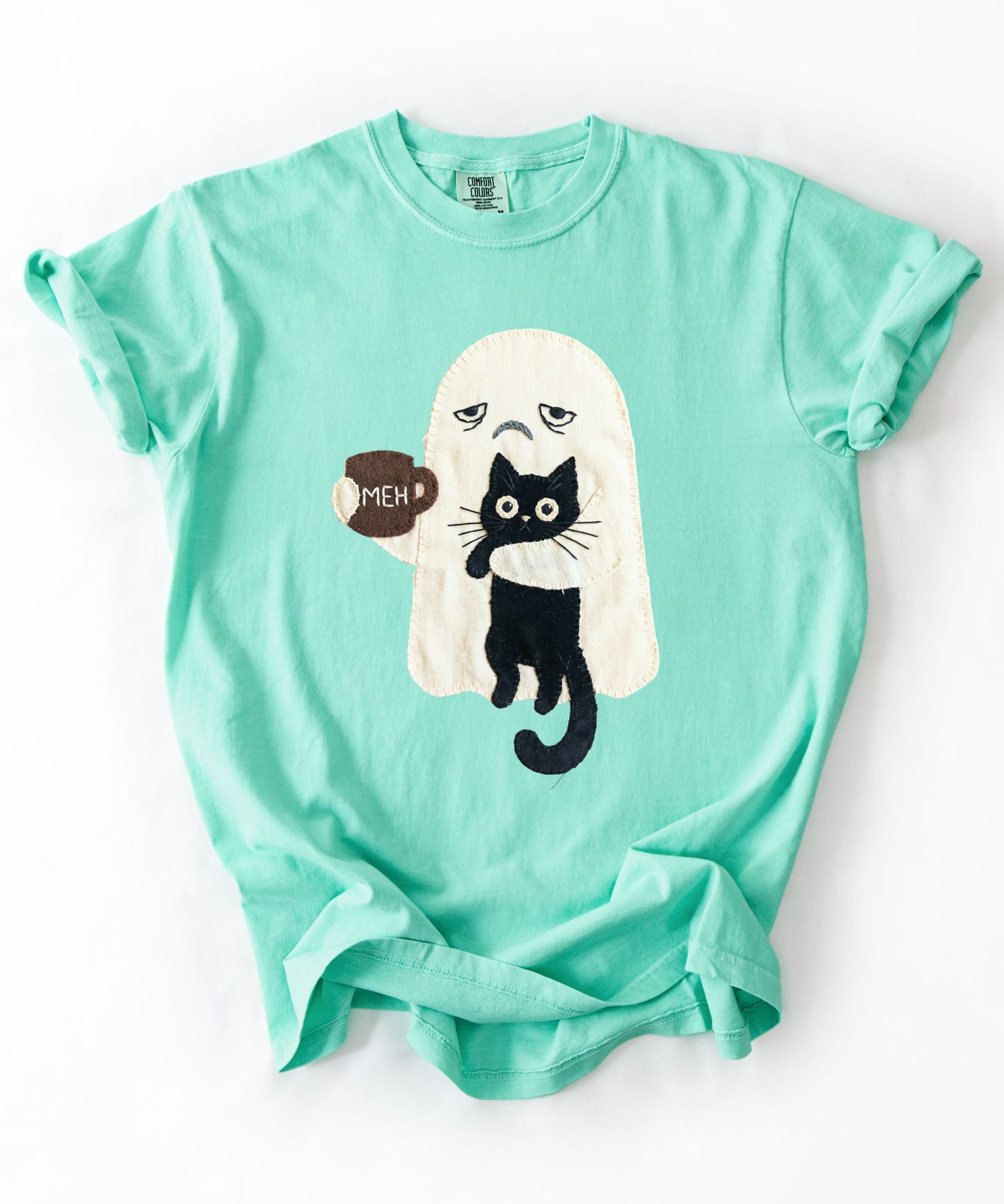 Grumpy ghost holding MEH mug with black cat graphic on Island Reef Comfort Colors garment-dyed tee