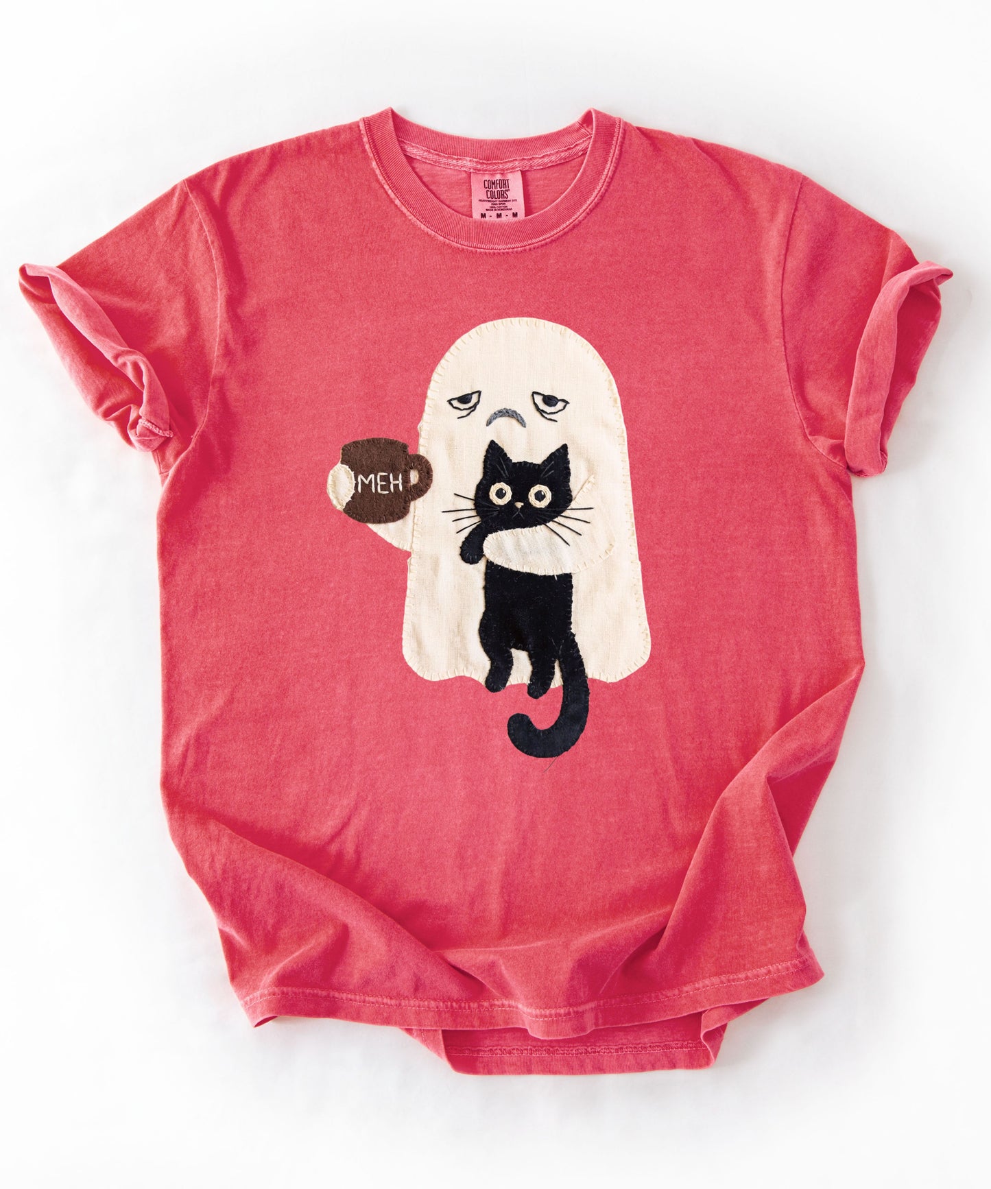 Grumpy ghost holding MEH mug with black cat graphic on Watermelon Comfort Colors garment-dyed tee