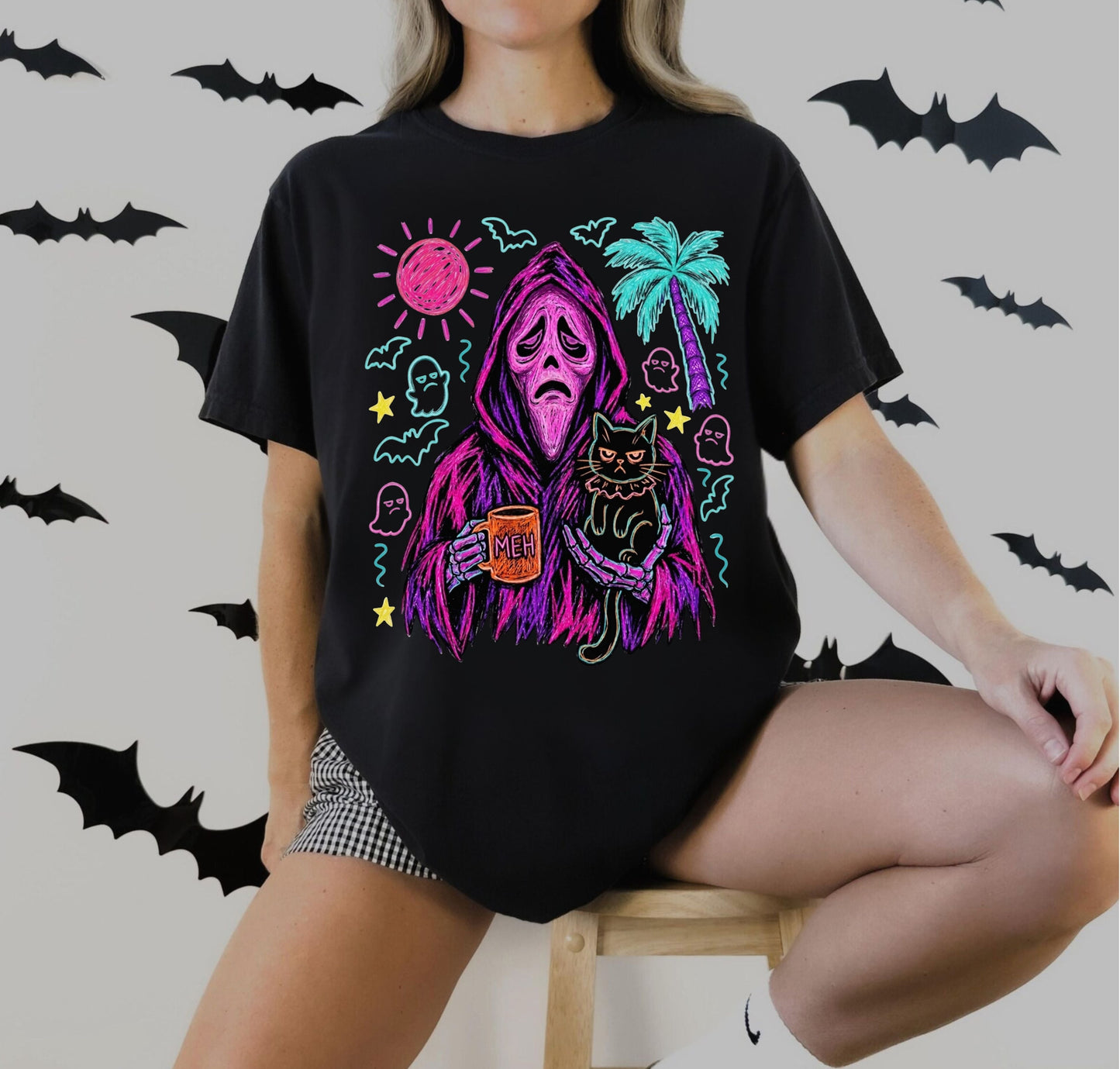 Neon Summerween reaper holding MEH mug and grumpy black cat graphic on black Comfort Colors tee