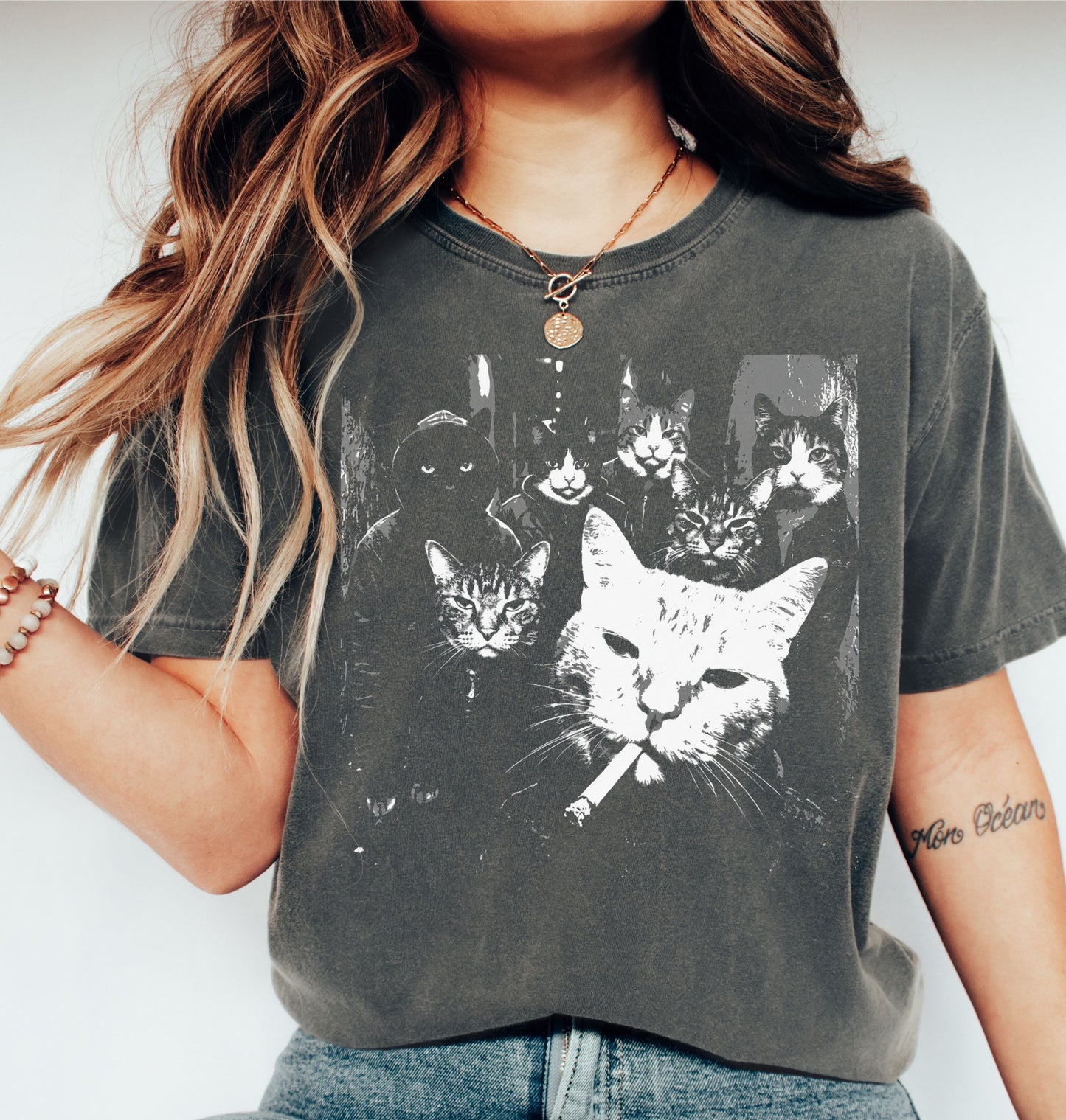 Close-up of a black-and-white cat gang graphic print on a t-shirt — six cats posed like a crime family, with a white boss cat smoking a cigarette front and center.