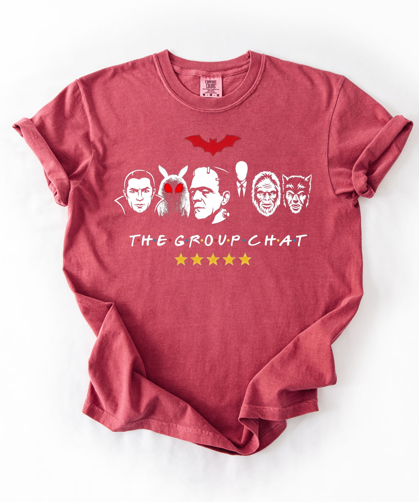 Crimson garment-dyed unisex t-shirt featuring The Group Chat horror monster squad graphic — Dracula, Mothman with red eyes, Frankenstein, Slender Man, Bigfoot, and Werewolf faces with red bat above and five gold stars below