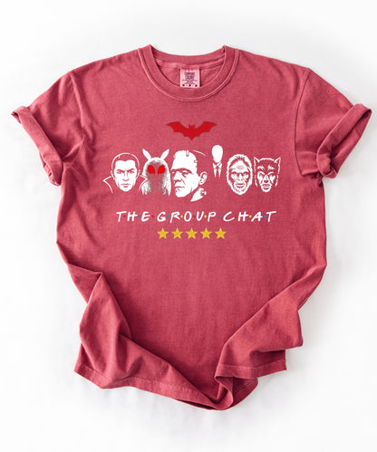 Crimson garment-dyed unisex t-shirt featuring The Group Chat horror monster squad graphic — Dracula, Mothman with red eyes, Frankenstein, Slender Man, Bigfoot, and Werewolf faces with red bat above and five gold stars below