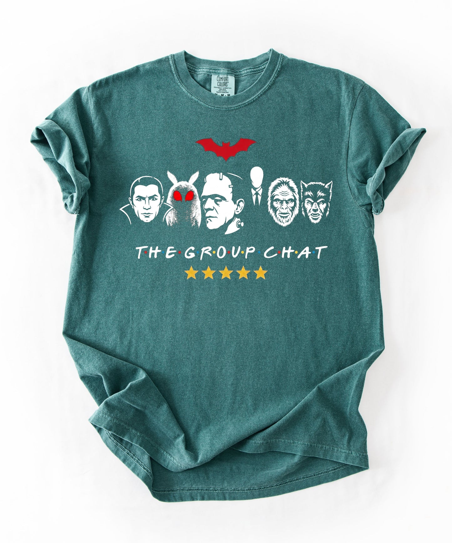Blue Spruce garment-dyed unisex t-shirt featuring The Group Chat horror monster squad graphic — Dracula, Mothman with red eyes, Frankenstein, Slender Man, Bigfoot, and Werewolf faces with red bat above and five gold stars below