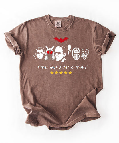Espresso garment-dyed unisex t-shirt featuring The Group Chat horror monster squad graphic — Dracula, Mothman with red eyes, Frankenstein, Slender Man, Bigfoot, and Werewolf faces with red bat above and five gold stars below