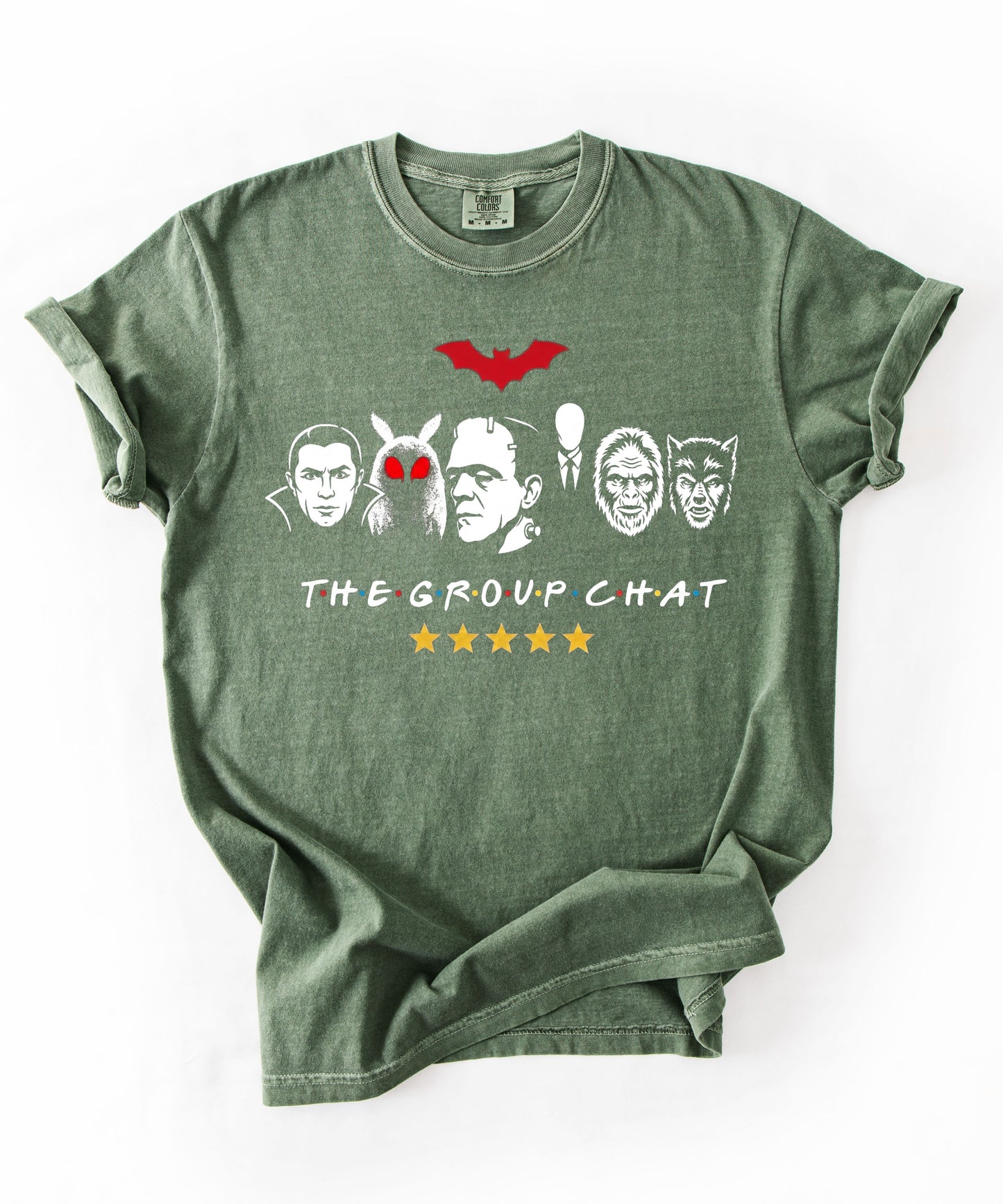 Moss garment-dyed unisex t-shirt featuring The Group Chat horror monster squad graphic — Dracula, Mothman with red eyes, Frankenstein, Slender Man, Bigfoot, and Werewolf faces with red bat above and five gold stars below