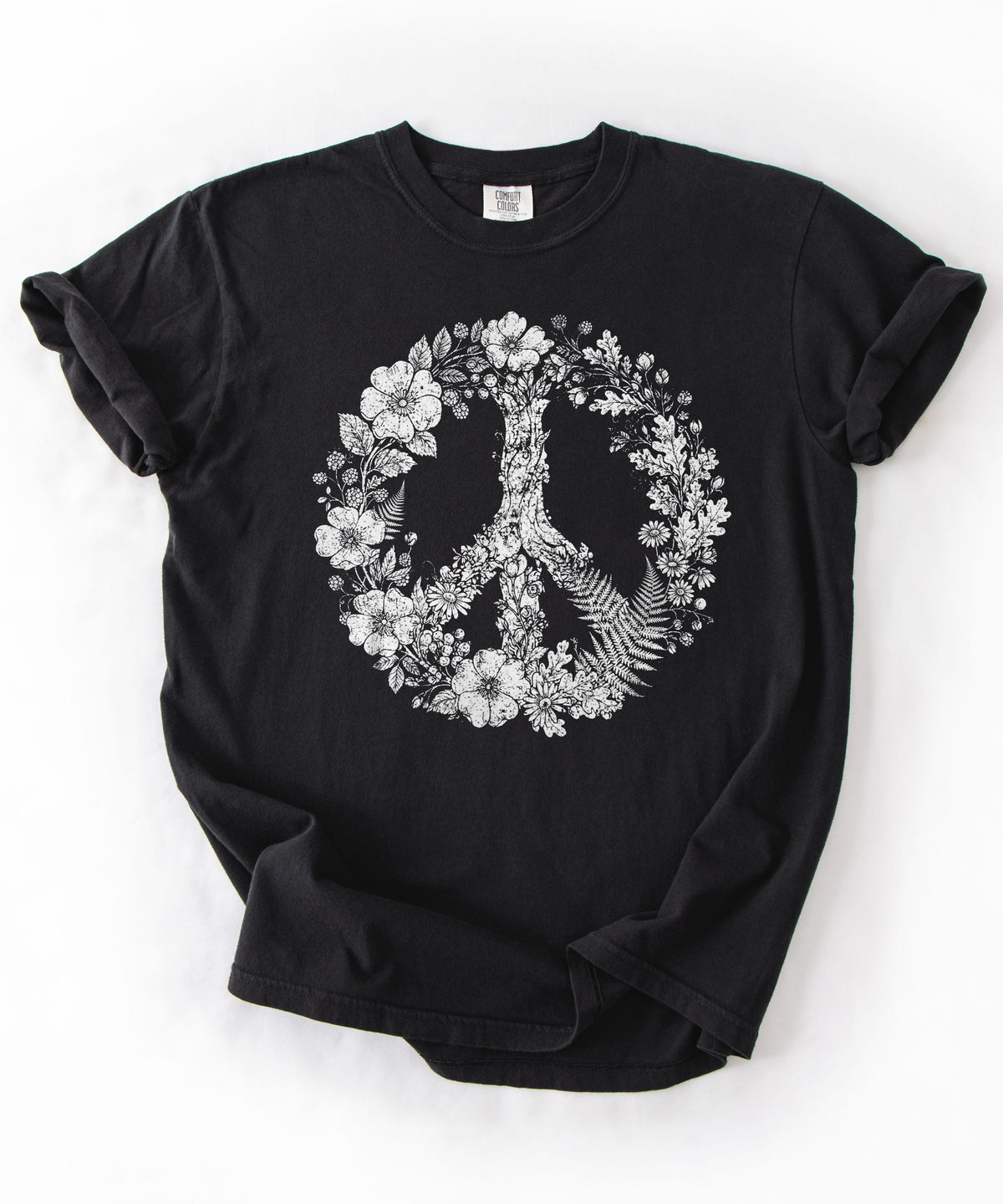 A black short-sleeve t-shirt with a white graphic of a peace sign formed by flowers and leaves, laid flat on a white background.