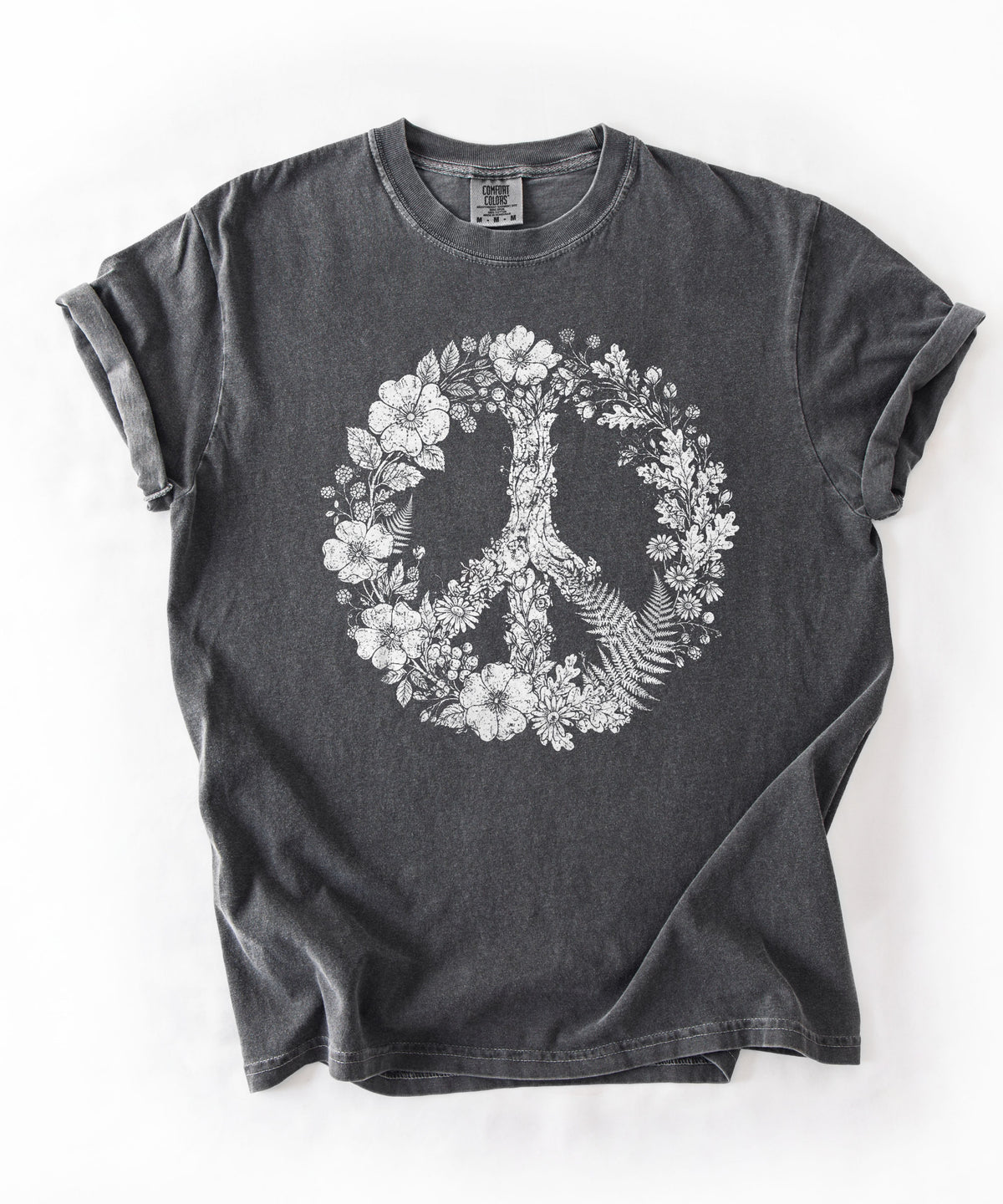 A Pepper washed t-shirt with a white graphic of a peace sign formed by flowers and fern leaves, laid flat on a white background.