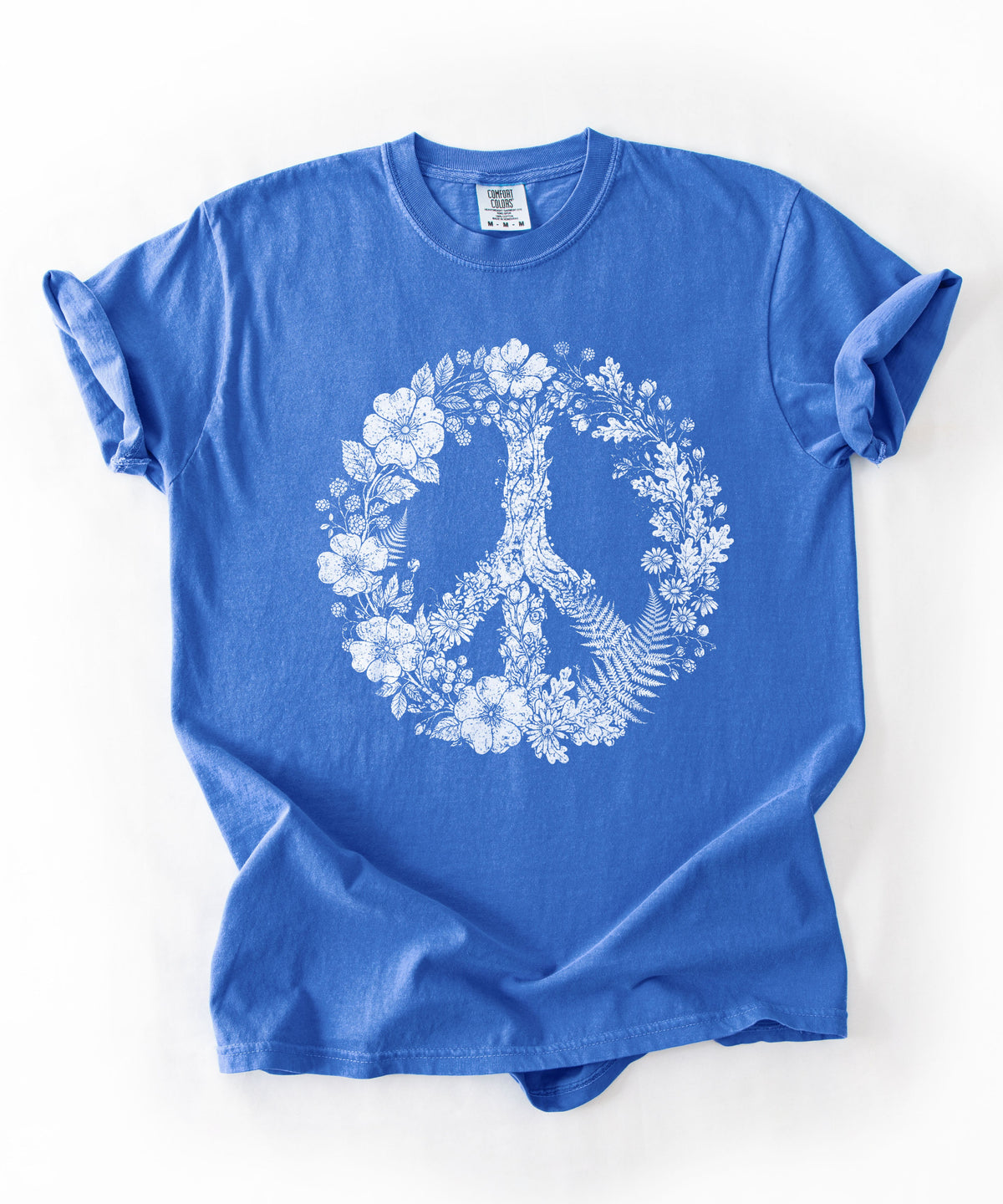A Flo Blue short-sleeve crewneck t-shirt with a white graphic print of a peace sign made of flowers and a bird, laid flat on a white background.