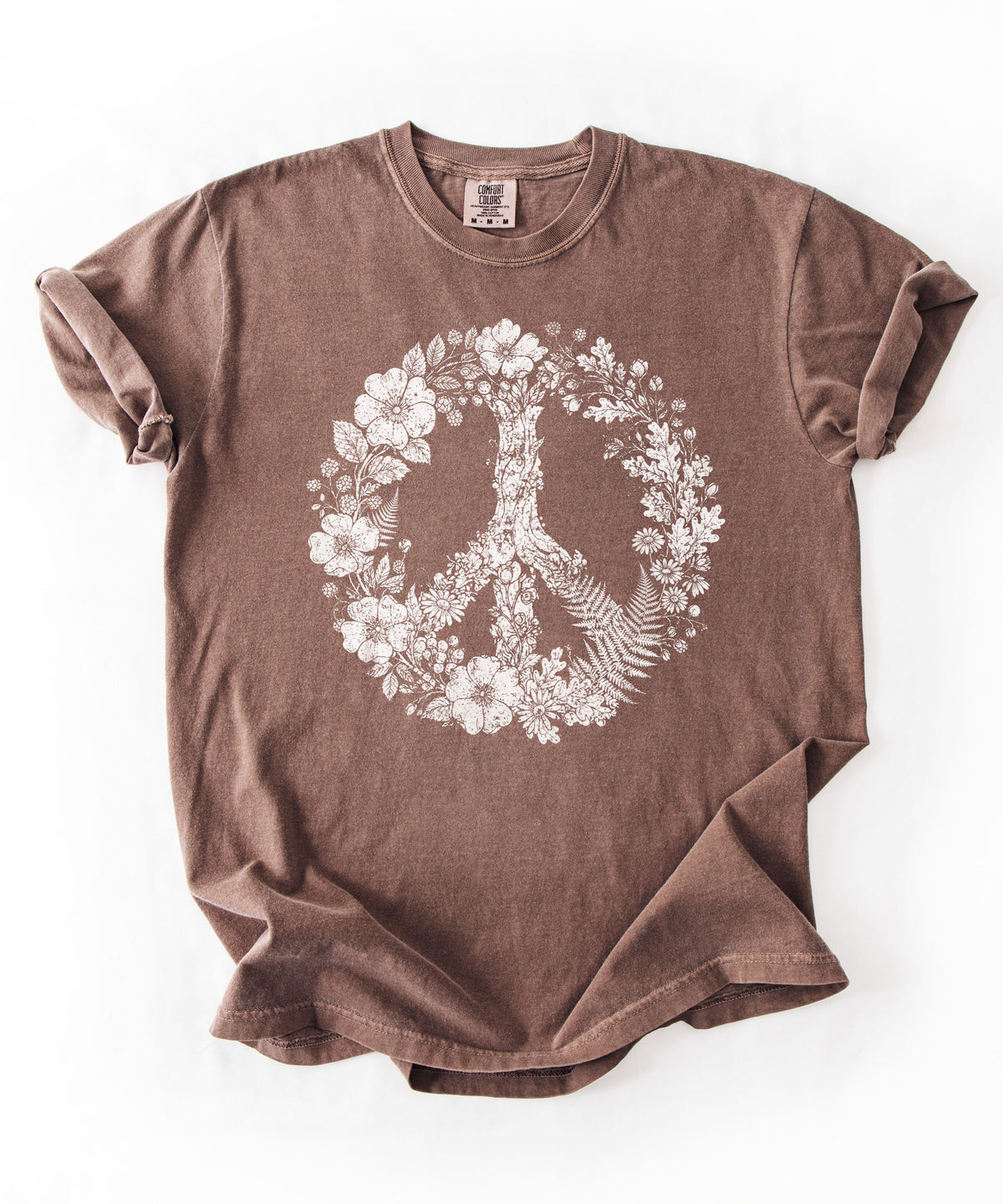 An Espresso short-sleeve t-shirt with a white graphic of a peace sign formed by a tree and floral wreath, laid flat on a white background.