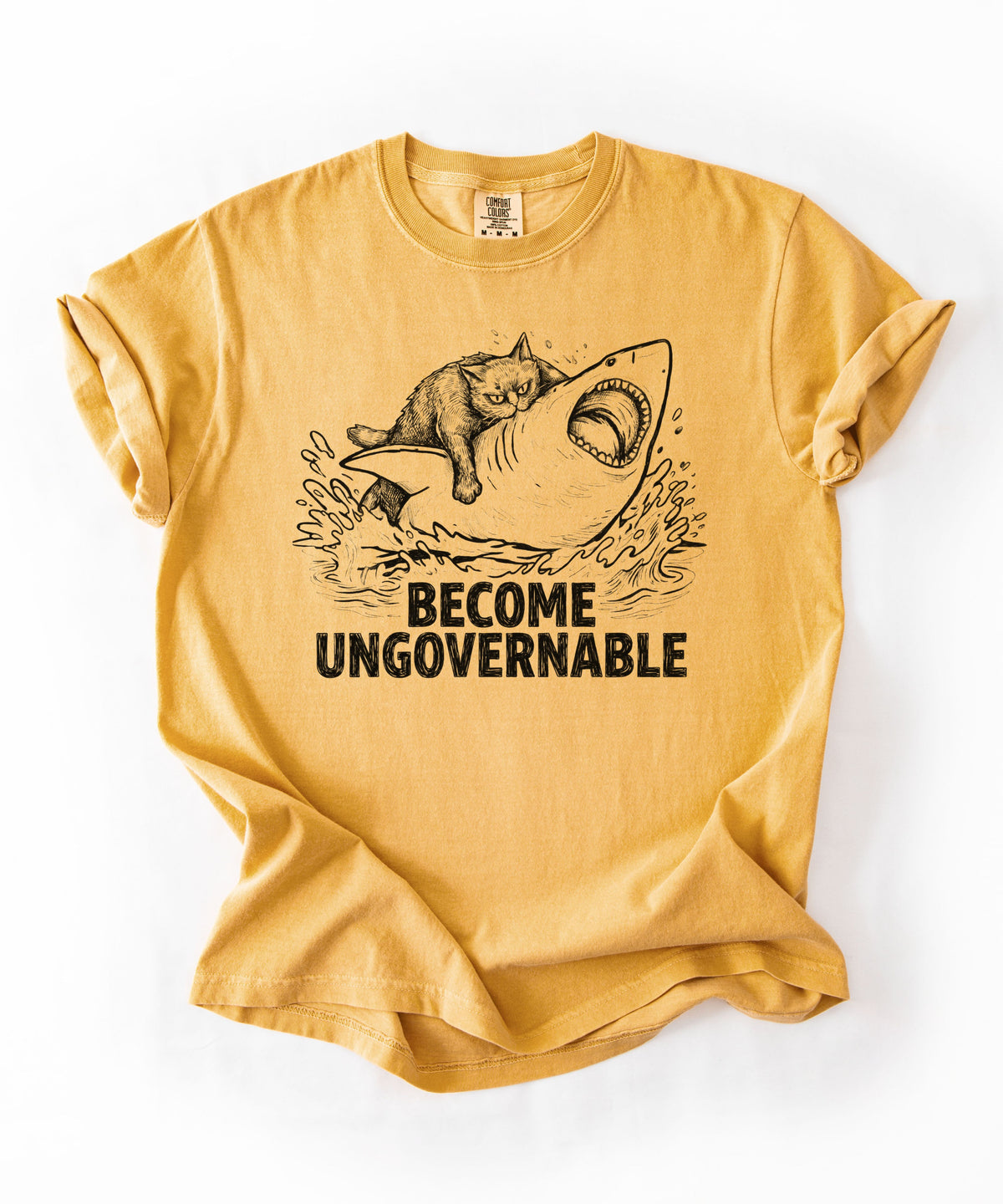 Mustard t-shirt with a red graphic of a cat on a Shark and the text 'BECOME UNGOVERNABLE'. 