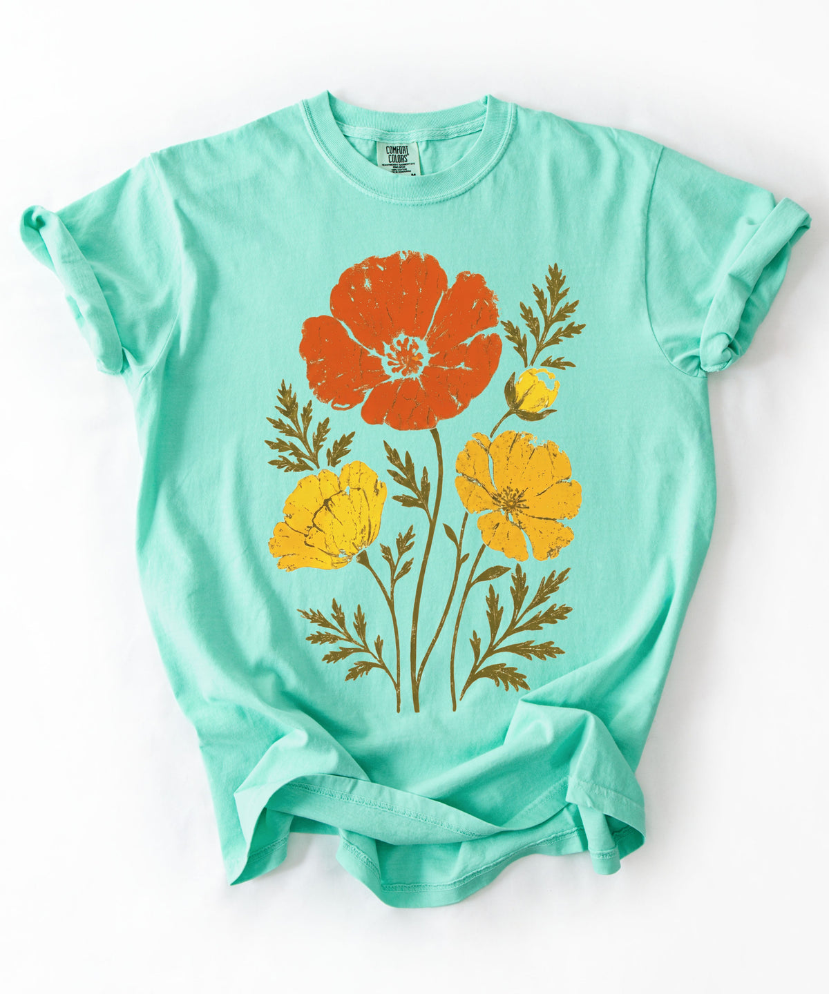 An Island Reef green short-sleeve t-shirt with a vintage-style poppy floral graphic in orange, yellow, and brown, laid flat 