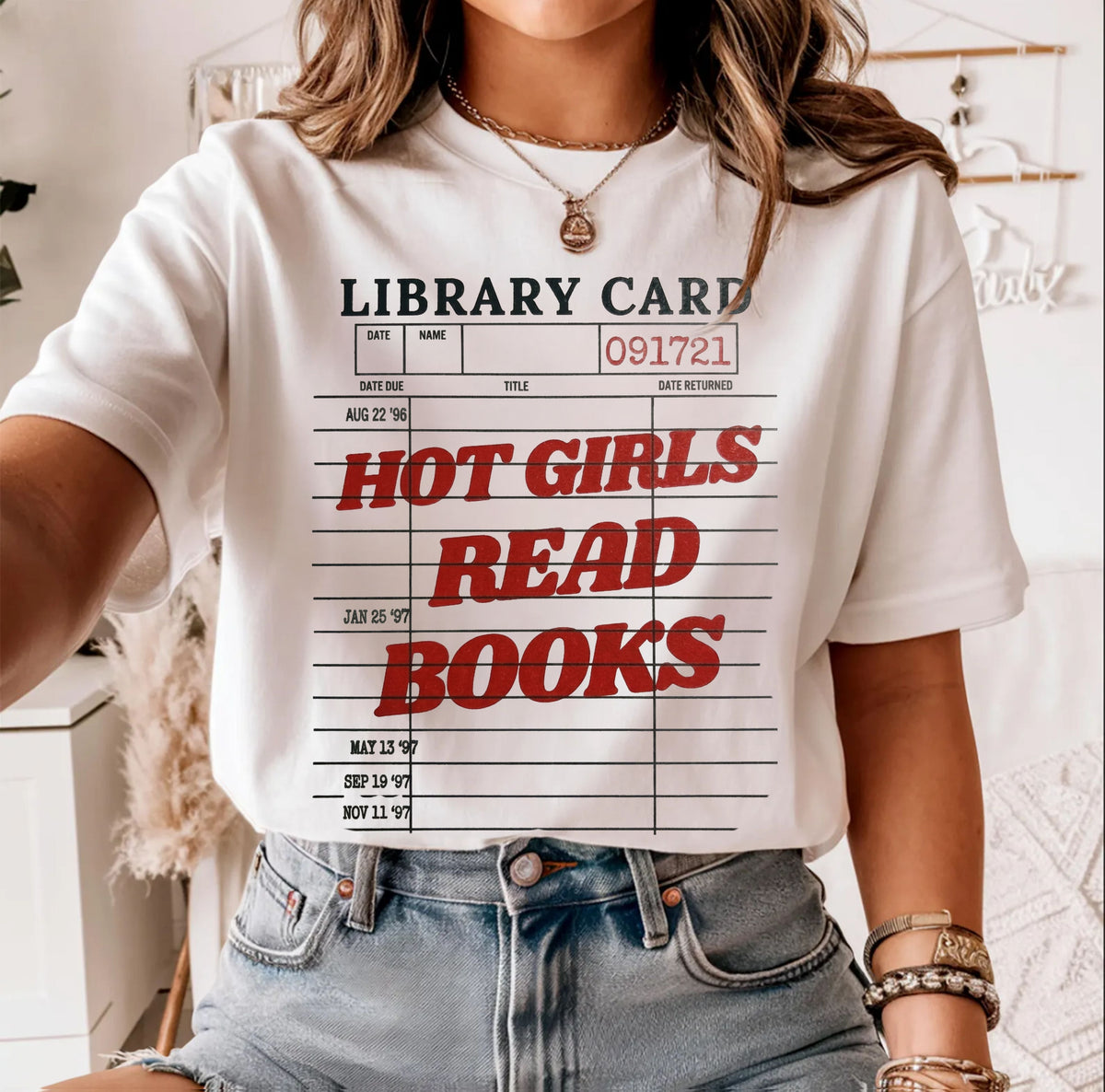 White Garment-dyed T-shirt with a vintage library card graphic reading “HOT GIRLS READ BOOKS.”

