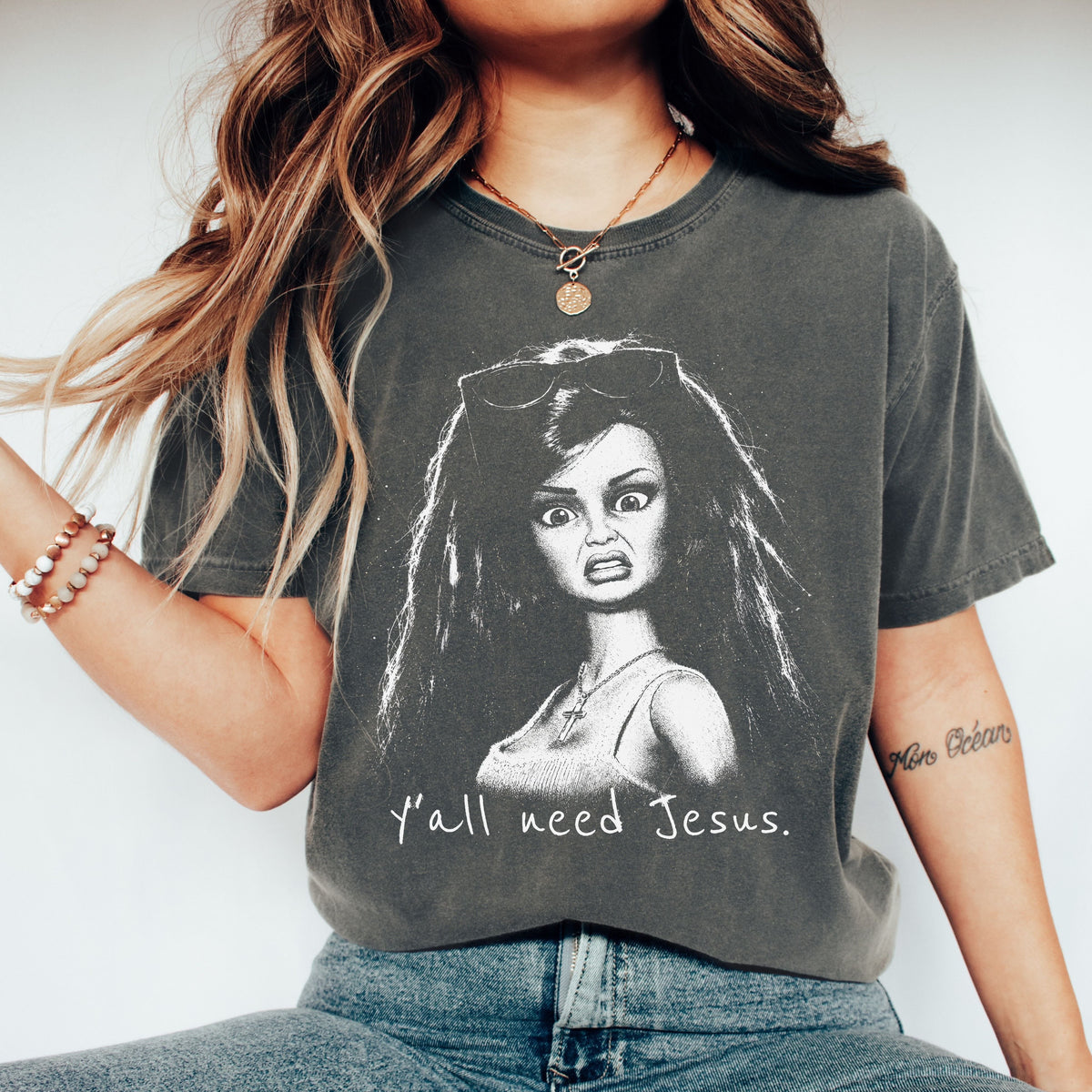 Pepper Y’all Need Jesus graphic T-shirt with a funny-faced doll design.