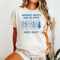 Ivory T-shirt with seven vintage women and blue text reading “Women’s rights vary by state. Men’s don’t.”