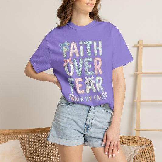 Person wearing a violet t-shirt with 'Faith Over Fear' text, standing against a neutral background.