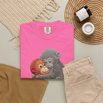 neon Pink t-shirt with monkey design on a neutral surface with accessories.