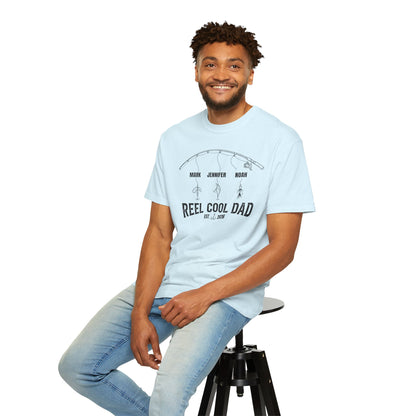 Man sitting on a stool wearing a Chambray blue t-shirt with text and light blue jeans on a white background