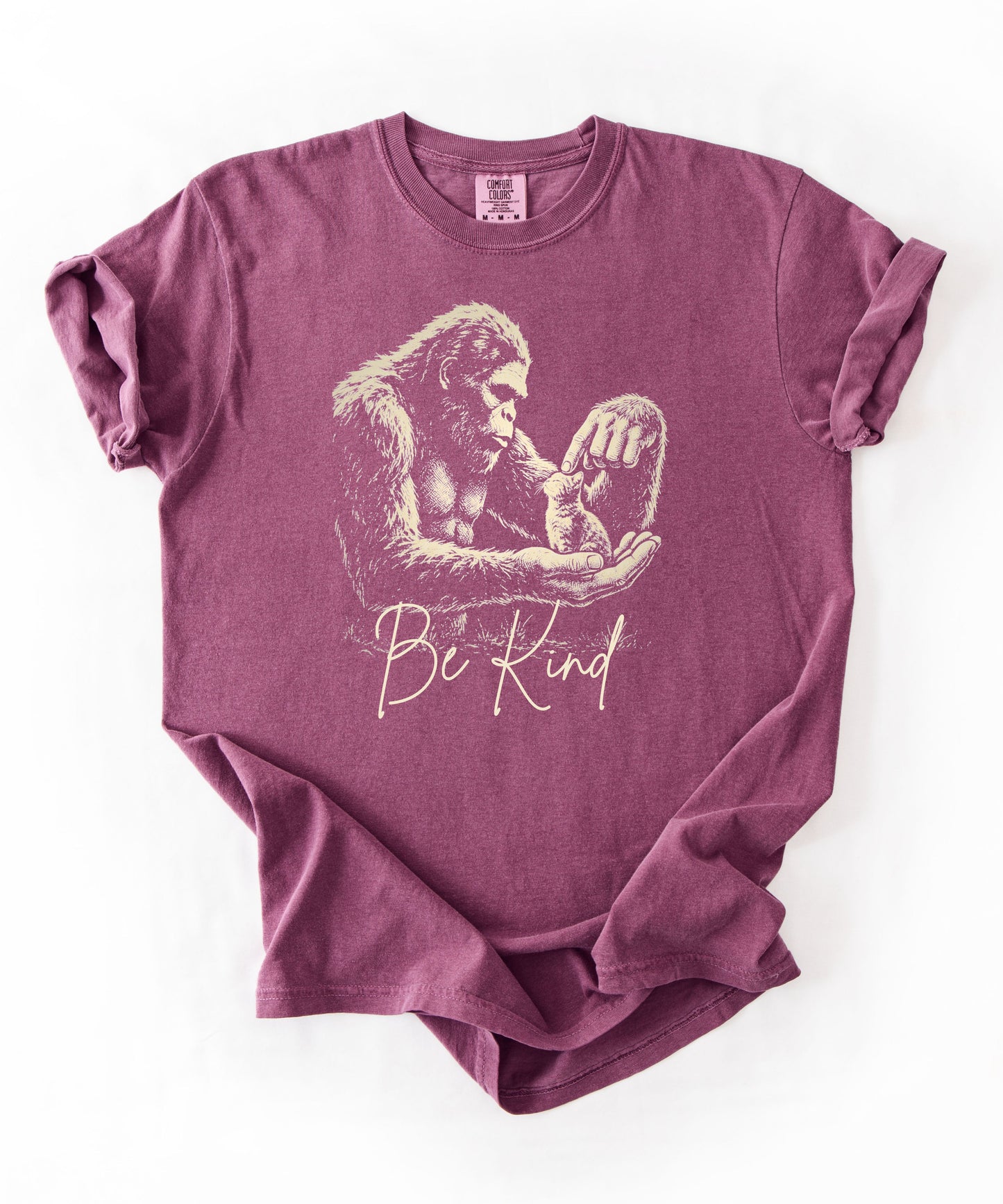 Bigfoot booping a cat on the nose graphic tee in berry — "Be Kind" garment-dyed heavyweight shirt