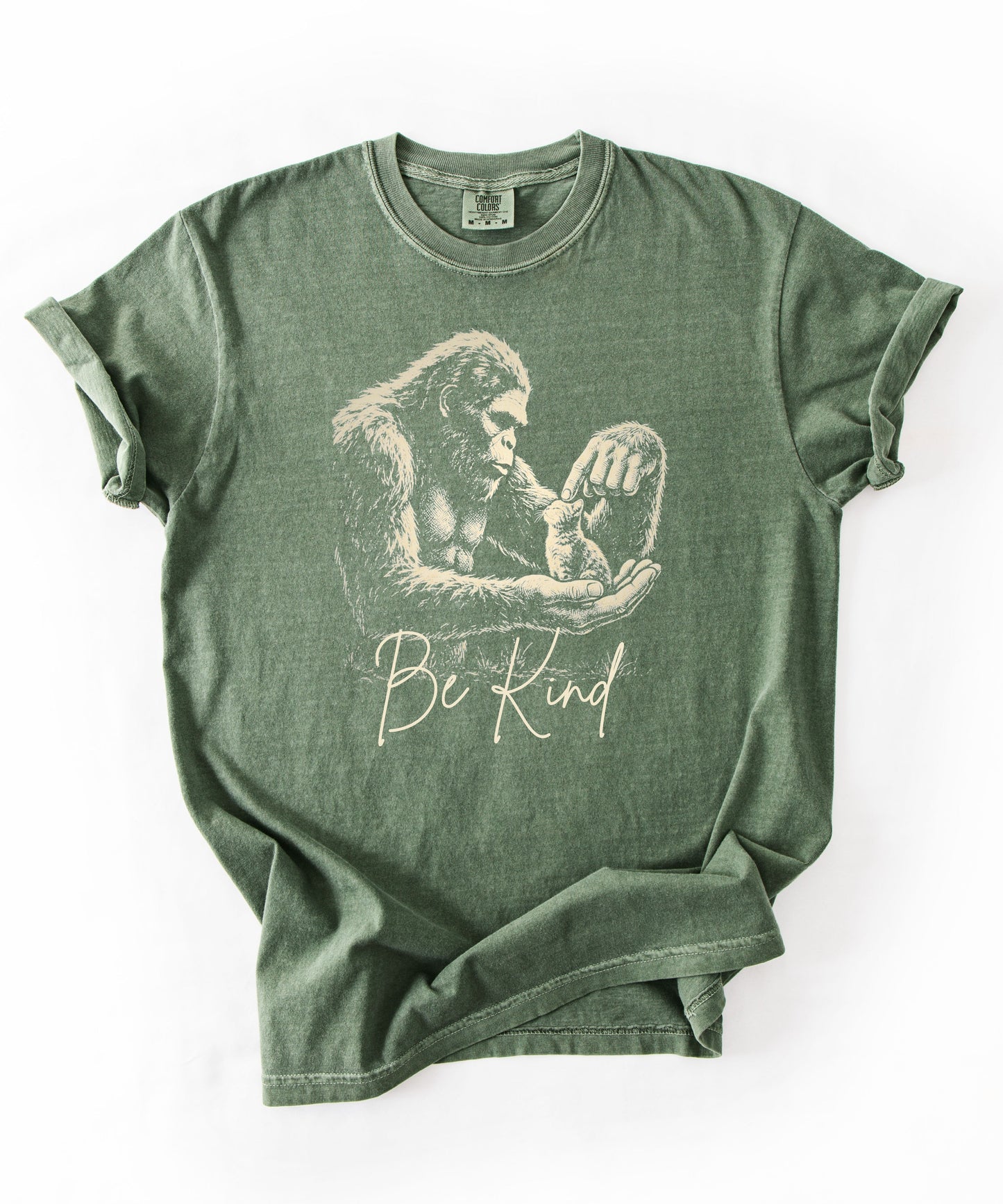 Bigfoot booping a cat on the nose graphic tee in Moss — "Be Kind" garment-dyed heavyweight shirt