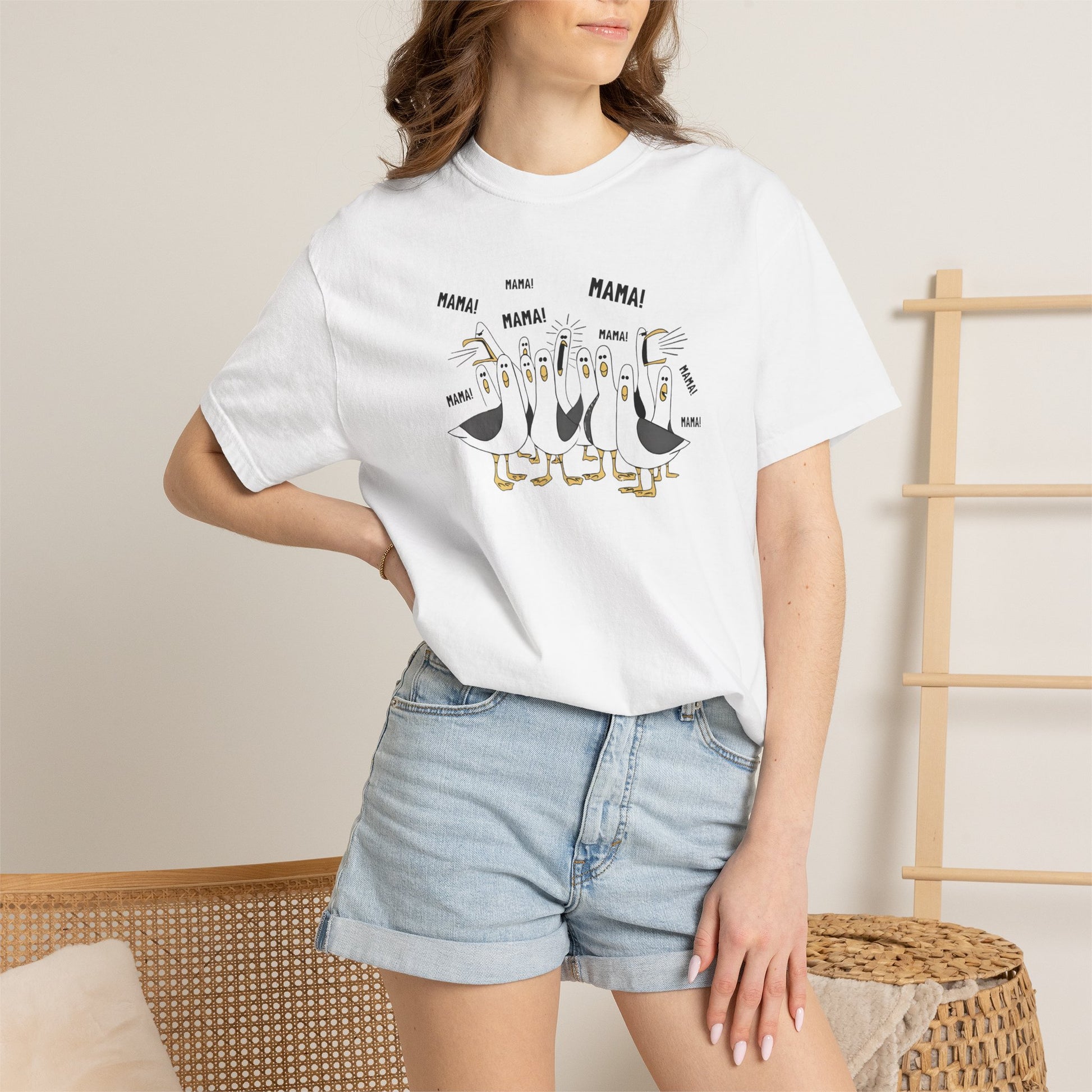 White t-shirt with cartoon penguins screaming "Mama"  design and text worn by a person.