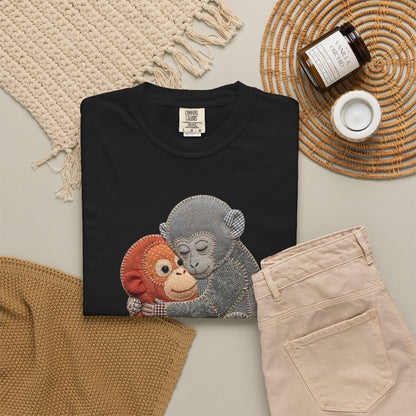 Black sweatshirt with monkey design on a neutral surface with accessories.