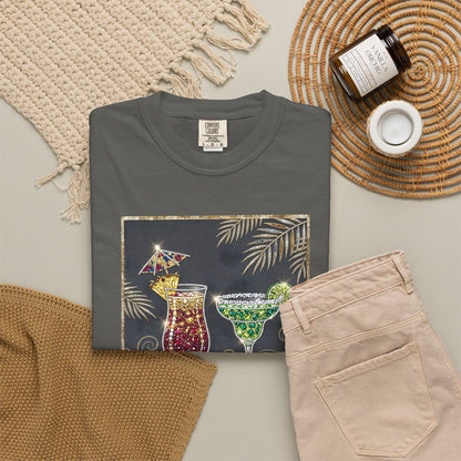 pepper t-shirt with cocktail graphic on a neutral surface with pants and decor items.