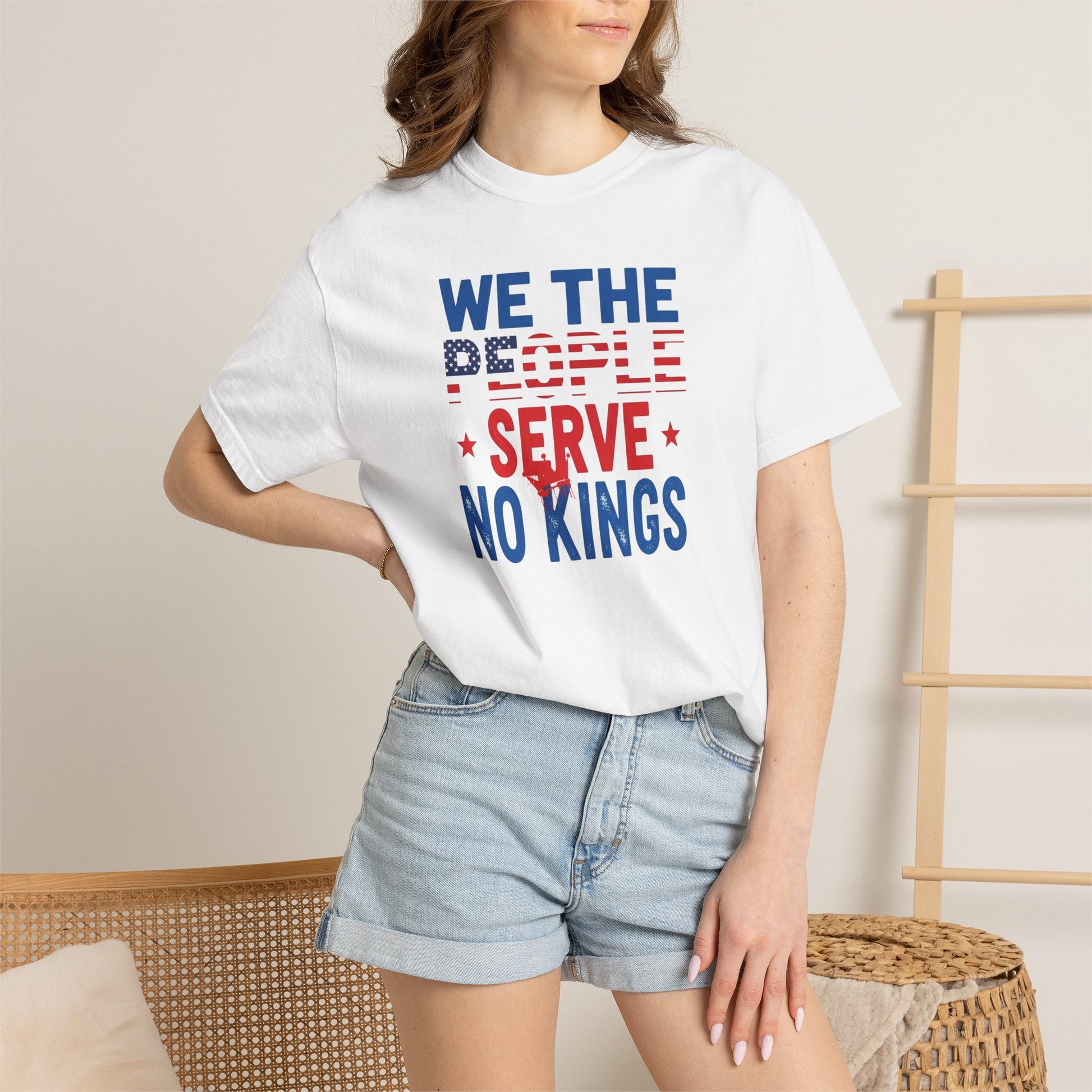 Person wearing a white t-shirt with 'We the People Serve No Kings' text in red and blue.