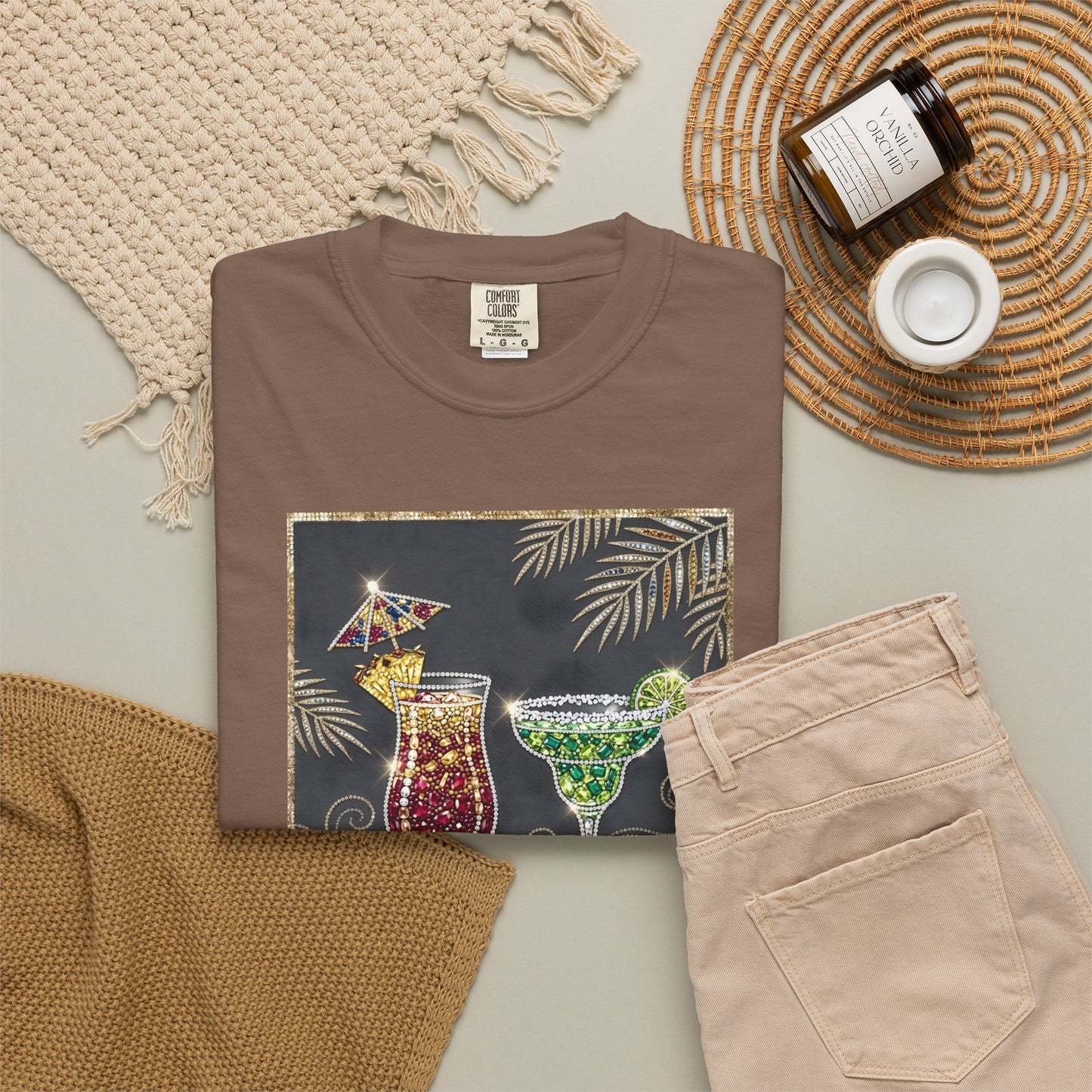 espresso t-shirt with cocktail graphic, beige pants, and decorative items on a neutral background