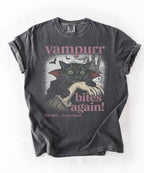 Funny Halloween cat shirt featuring a black cat in a vampire cape, bats, and the text “Vampurr Bites Again! in Pepper color 