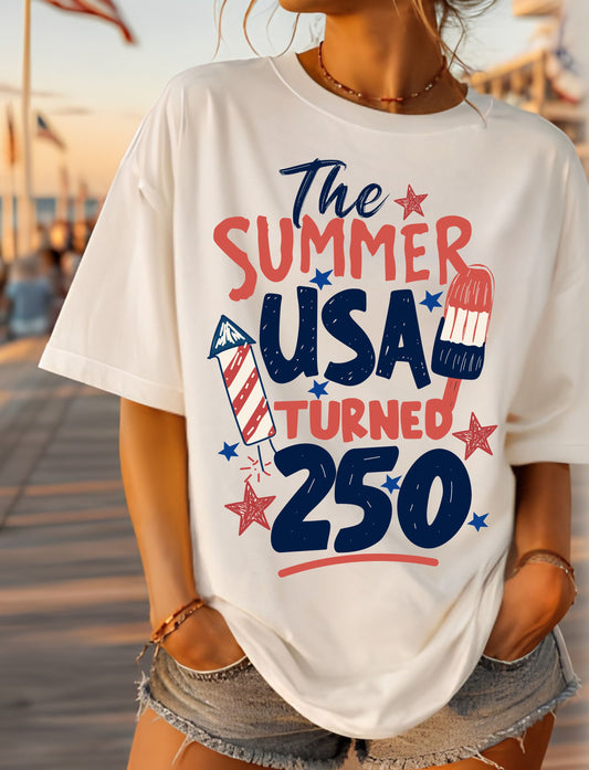 Person wearing a white t-shirt with 'The Summer USA Turned 250' design.